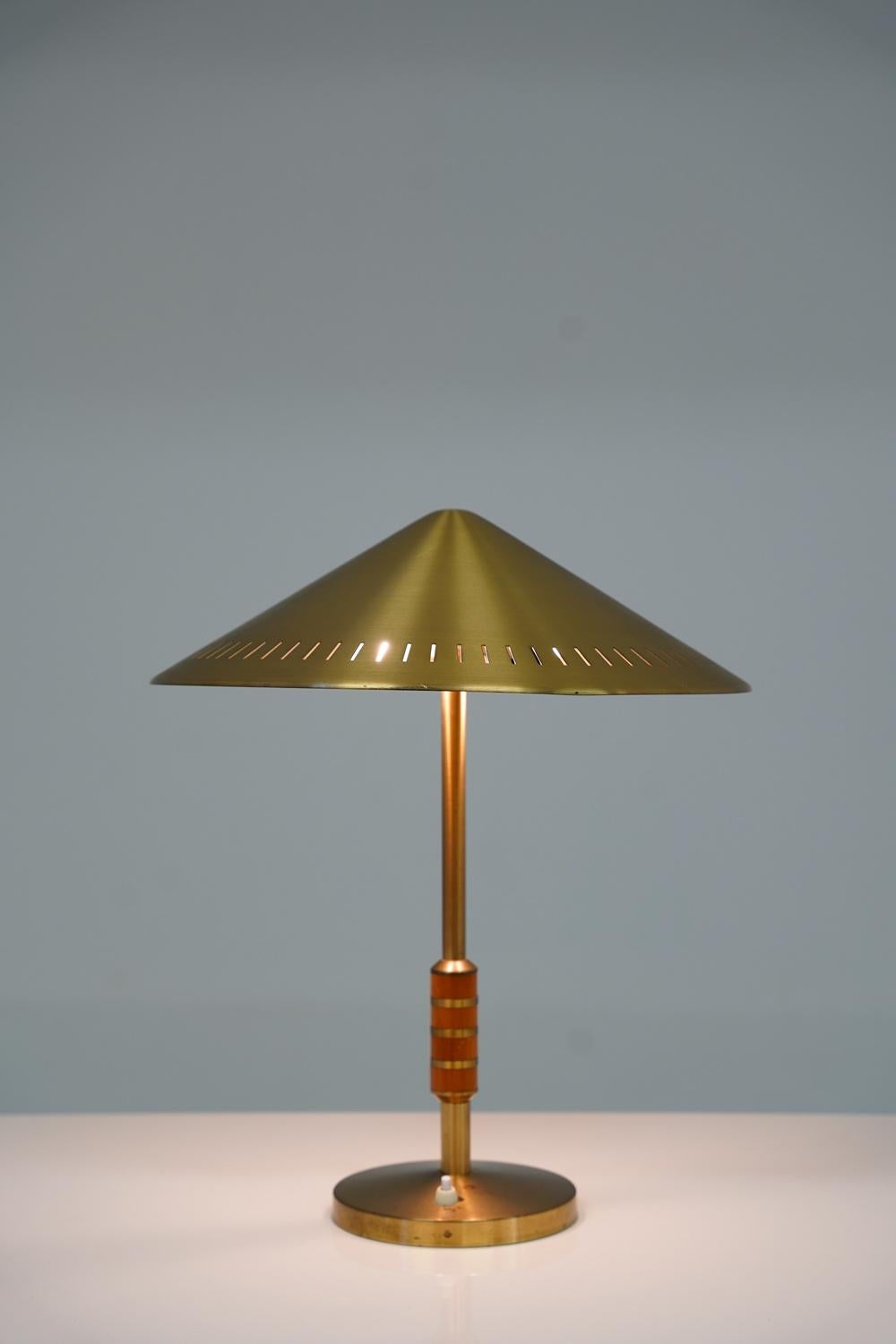 Rare table lamp model 8403 by Boréns, Sweden. 
This lamp is made of solid brass with details in teak and features a beautiful perforated shade. 

Condition: Very good original condition with a few spots on the base.