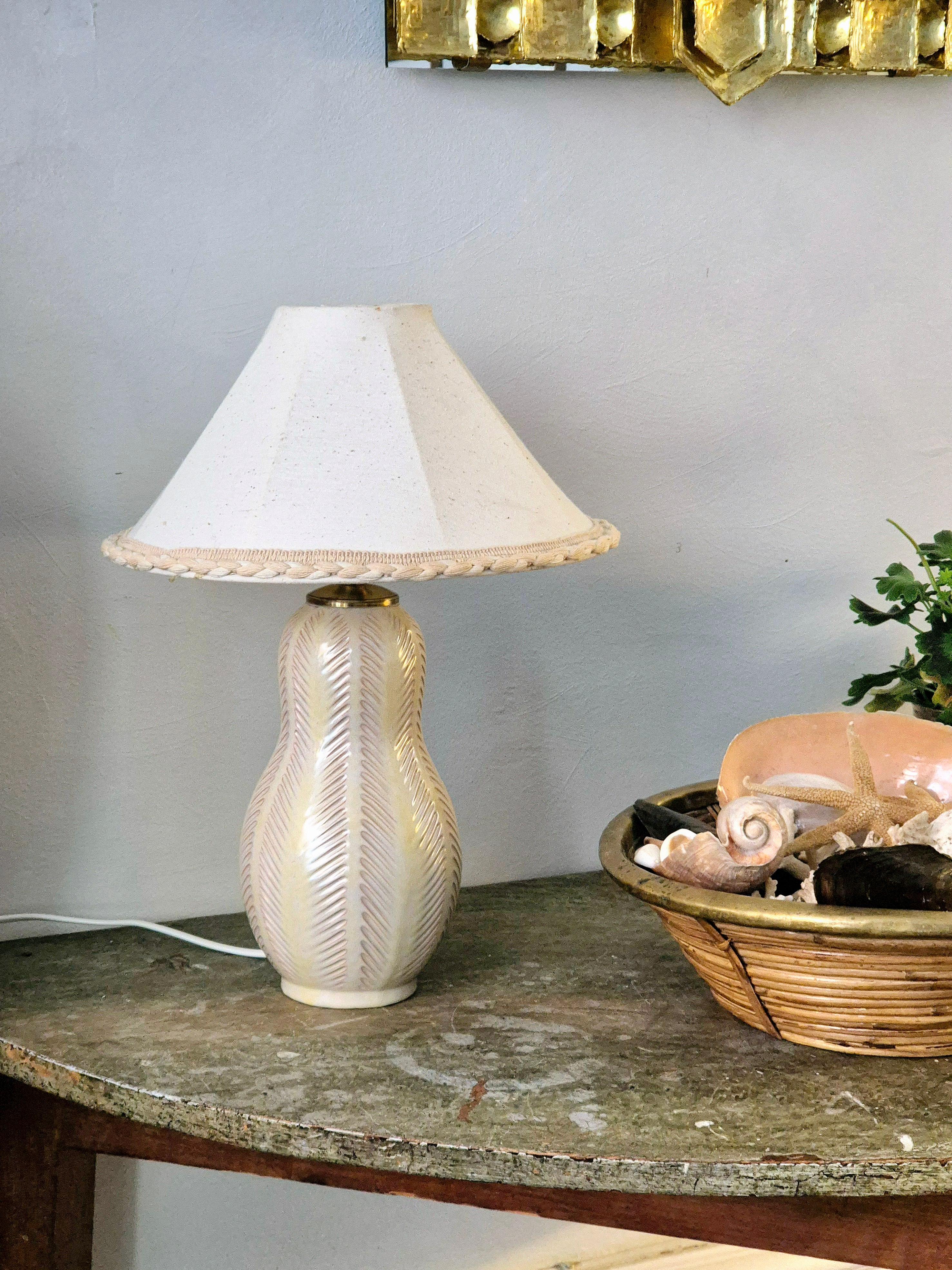 Beautiful earthenware table lamp with white glaze. Designed by Anna-Lisa Thomson for Upsala Ekeby Sweden, mid1900s.

Beautiful decor and original shade. Nice patina. Smaller signs of age and wear. 