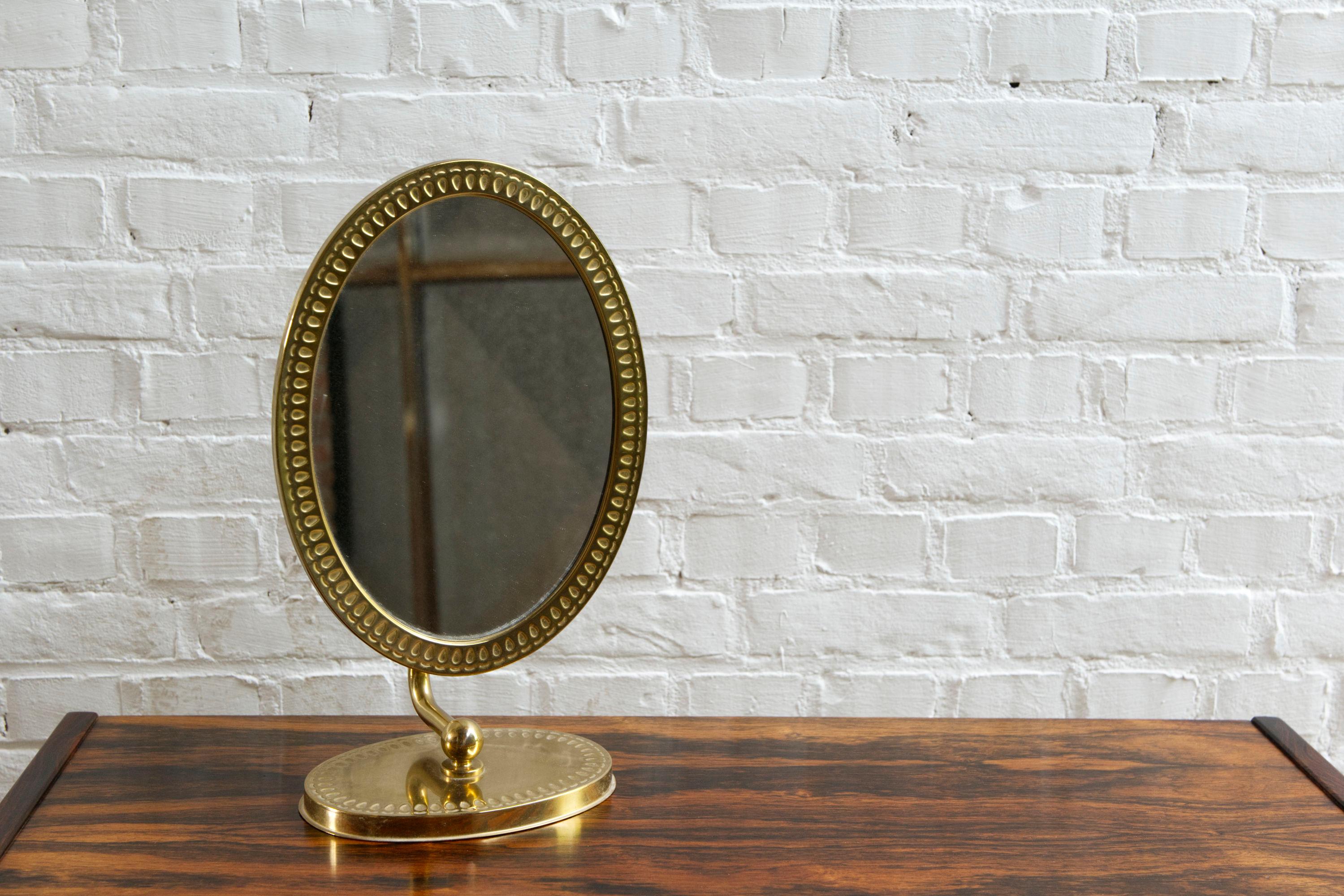 A beautiful 'Swedish modern' brass table mirror from Swedish manufacturer 'Titti'. Labeled on the bottom with article number 4.186.

Adjustable from vertical to horizontal position and in angle. Compact in size and perfect for use on a make up table