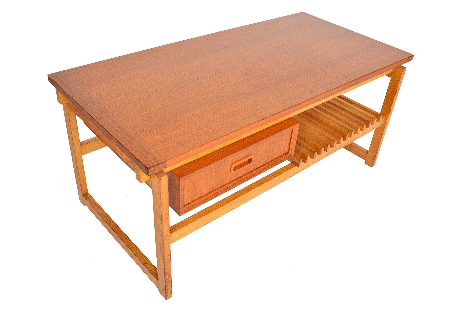 This Swedish modern midcentury coffee table in teak and oak is beautifully designed. The teak top is supported by an oak sleigh base. A single drawer in teak sits beneath the tabletop. A slatted oak rack runs the bottom of the table and offers