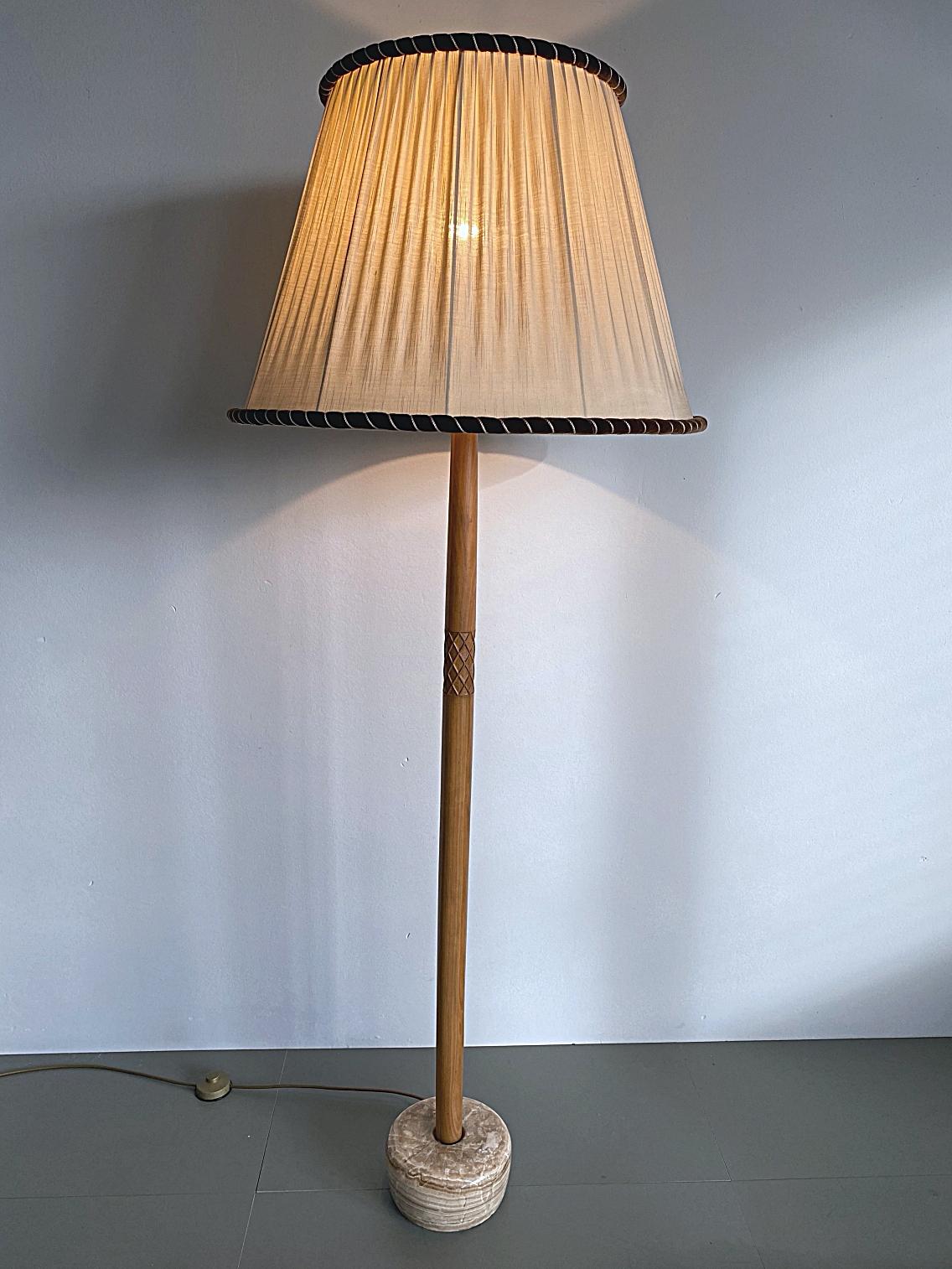 Elégant lampadaire du milieu du siècle fabriqué en Suède. La lampe est faite d'une tige en bois de teck effilée et sculptée à la main, avec des détails en laiton très fins et une lourde base en marbre Breccia. Le grand abat-jour original fournit une