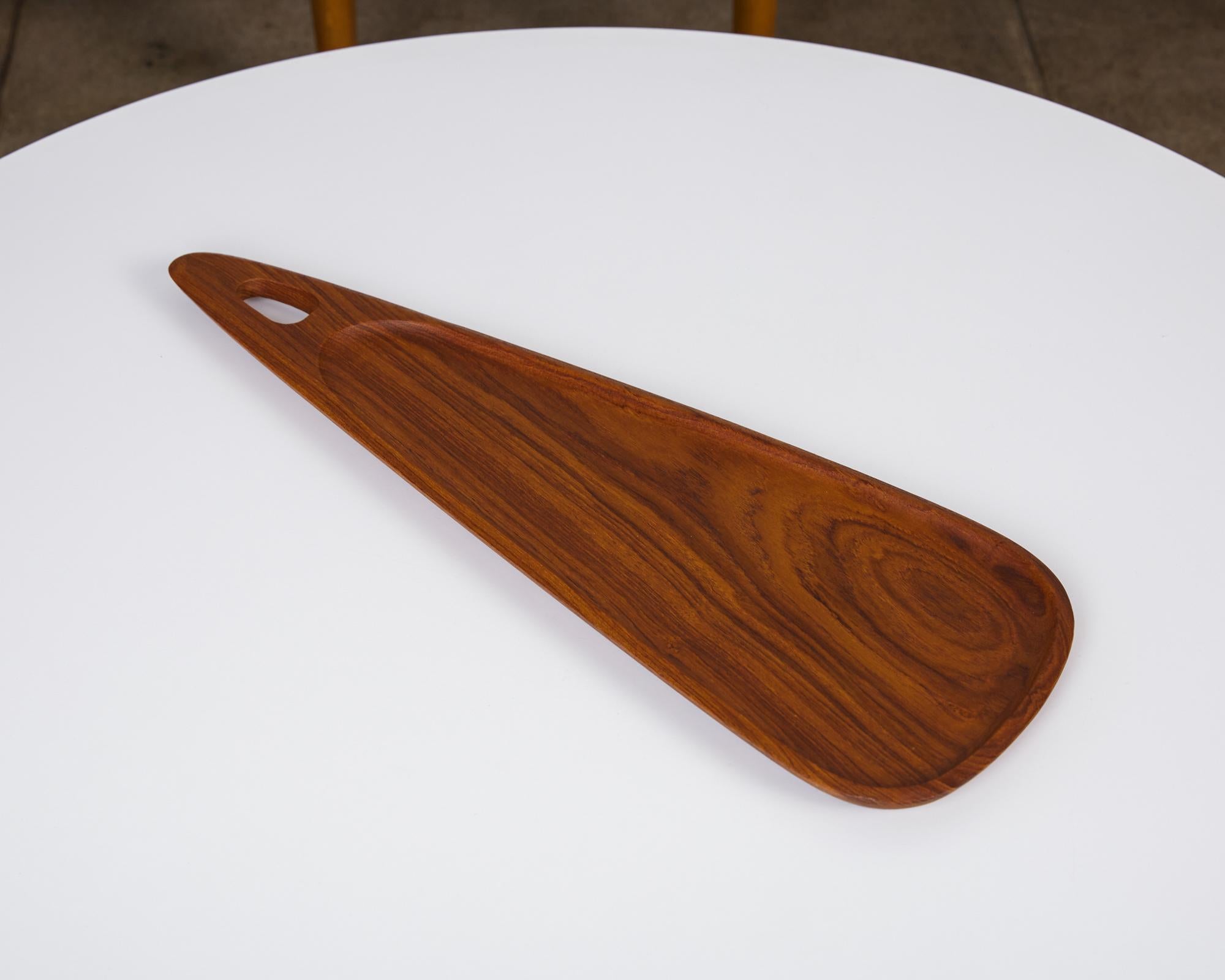 Asymmetrical teak serving tray by SS Design, circa 1960s. A beautifully grained solid teak asymmetrical serving or display tray. The tray has a gentle recess, almost the size of the entire piece, that leaves a slim but sturdy edging detail. The