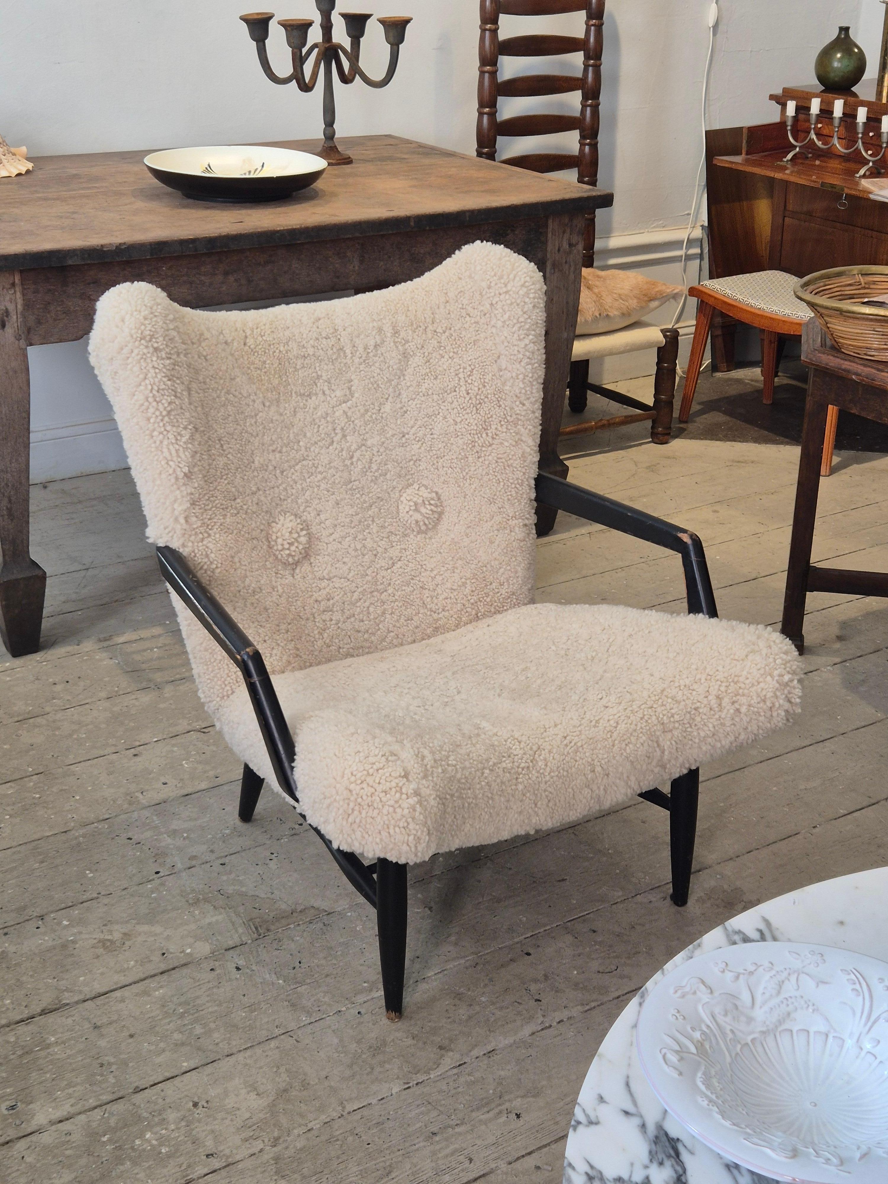 A rare armchair model attributed Svante Skogh, Stil & Form, Sweden 1950s. 
Beautiful sculptural wooden frame, colored black. Nice patina with natural color fade due to age and use. Re-upholstered in high quality sheepskin by professional