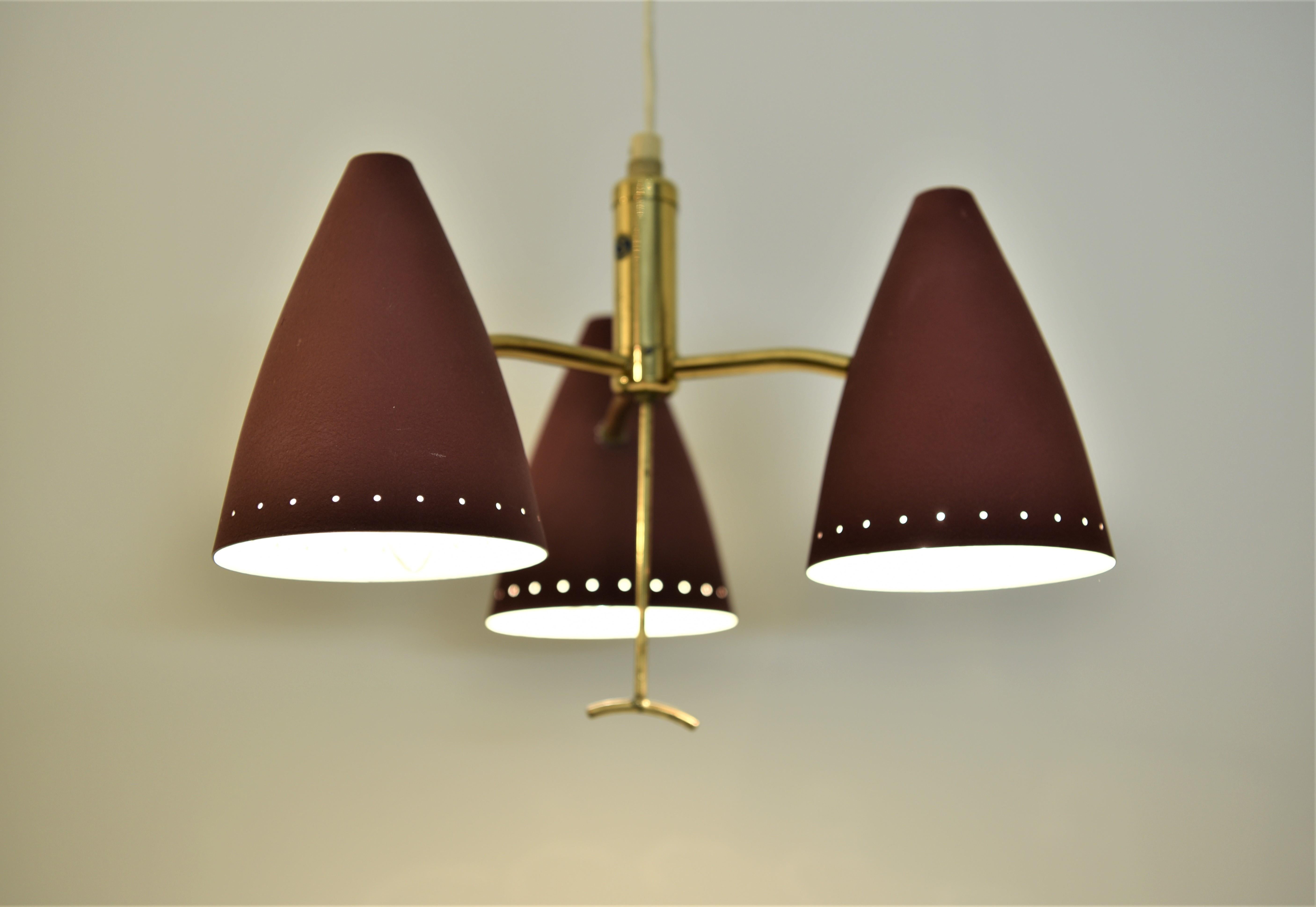 Swedish Modern Triple Pendant Lamp with Elevator Function 1950s.

Rare Swedish triple pendant lamp with an elevator function in brass. The lamp is in good original condition with only minor wear to the red paint and some minor oxidation to the