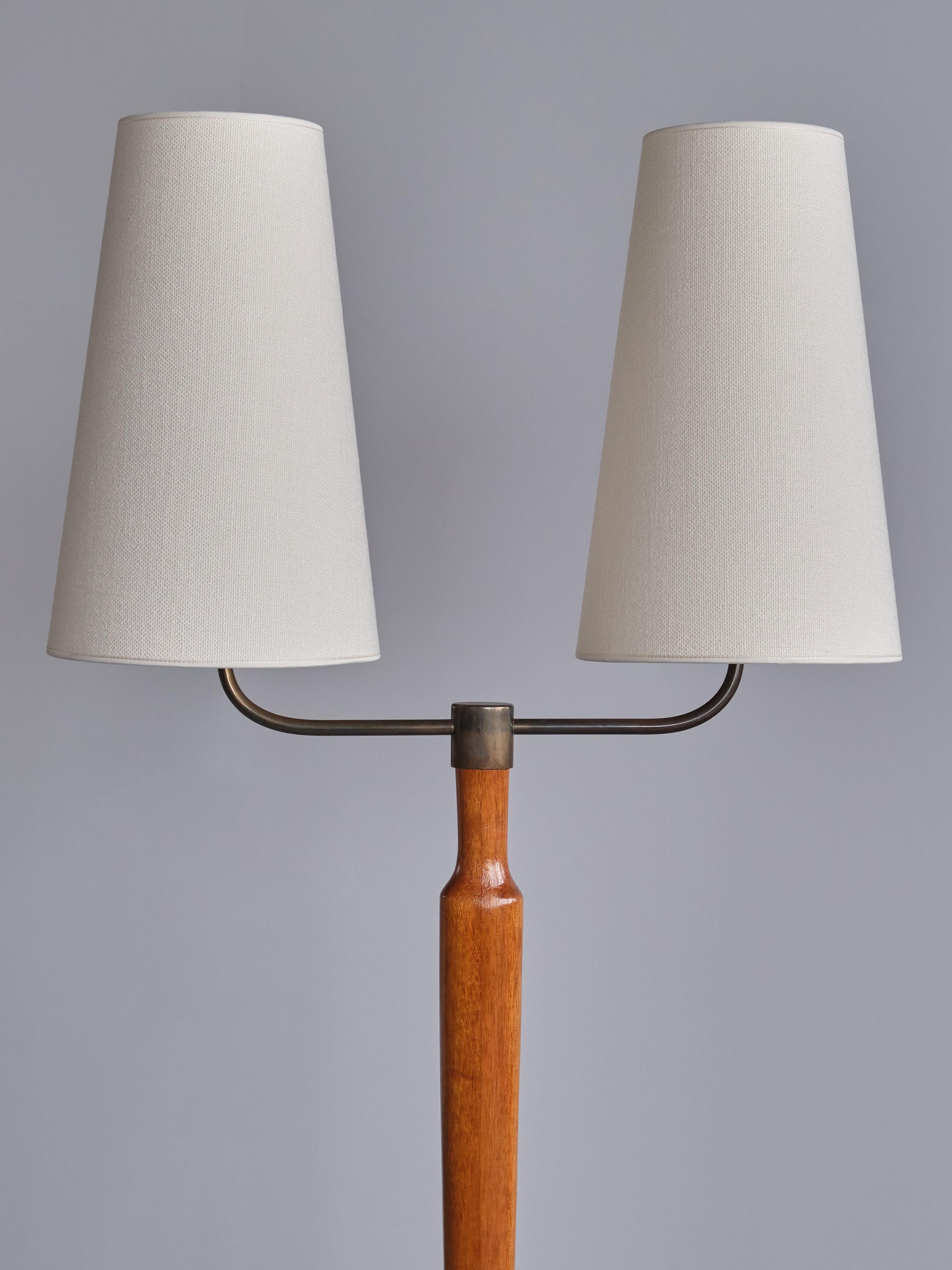This elegant floor lamp was produced in Sweden in the late 1940s. The lamp is made of solid teak wood, with a warm and attractive grain. The design consists of slightly raised base in a rounded rectangular shape. Central stem in a tapered shape and