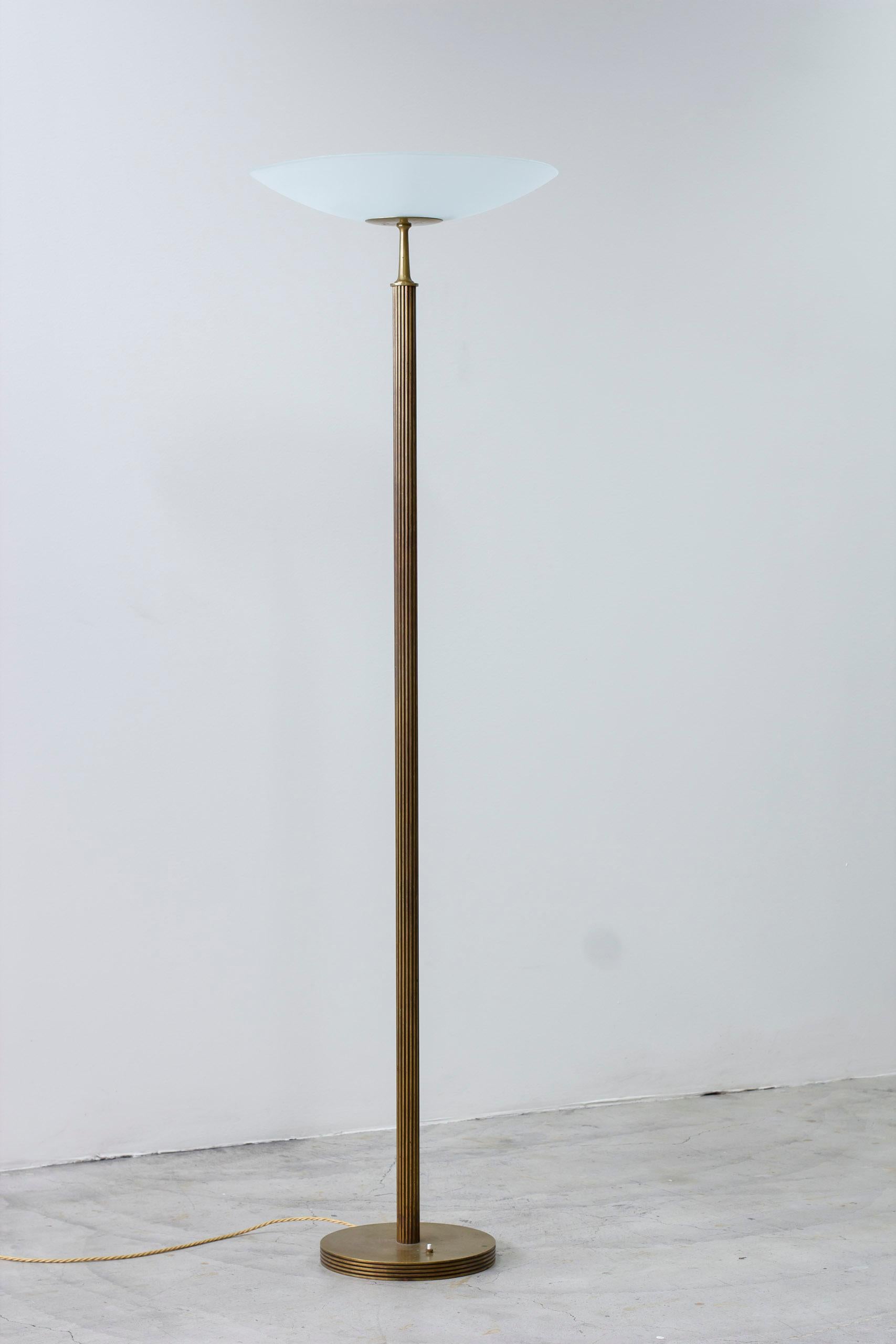 Floor lamp model 2614 produced by Bröderna Malmströms Metallvarufabrik, in Malmö, Sweden. First published in the Malmströms product catalog in 1938. Made from brass with a fluted profile with frosted glass shade uplight. Light switch on the base in