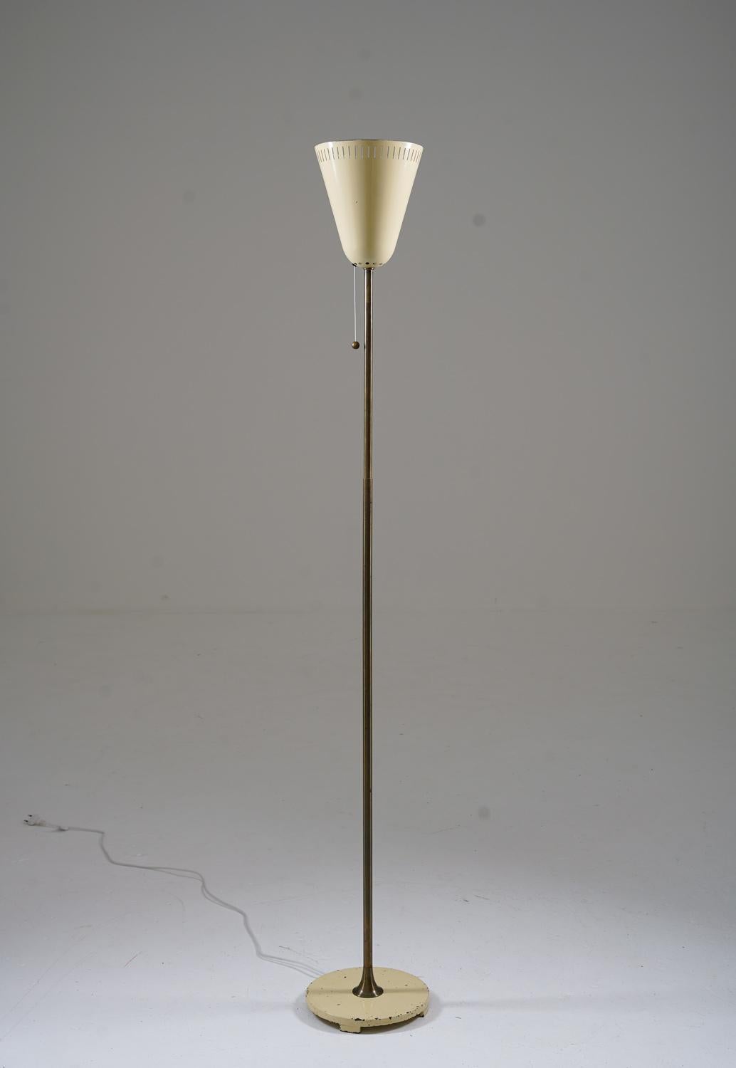Lampadaire d'ASEA, Suède, années 1940.
Belle lampe au design minimaliste avec de beaux détails. La base présente sa peinture blanc-crème d'origine, tandis que la tige est en laiton. La source lumineuse est cachée par un abat-jour en métal perforé de