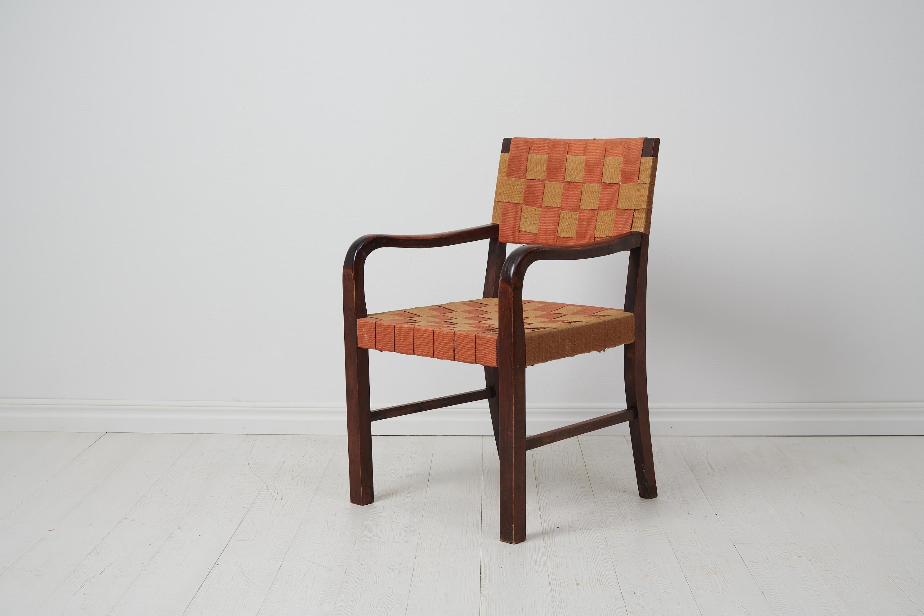 Swedish modern vintage armchair made during the early 20th Century, circa 1920 to 1930. The chair has a frame in birch which has been stained dark brown and polished. The seat and back both have the original weaving. The armchair is likely by the