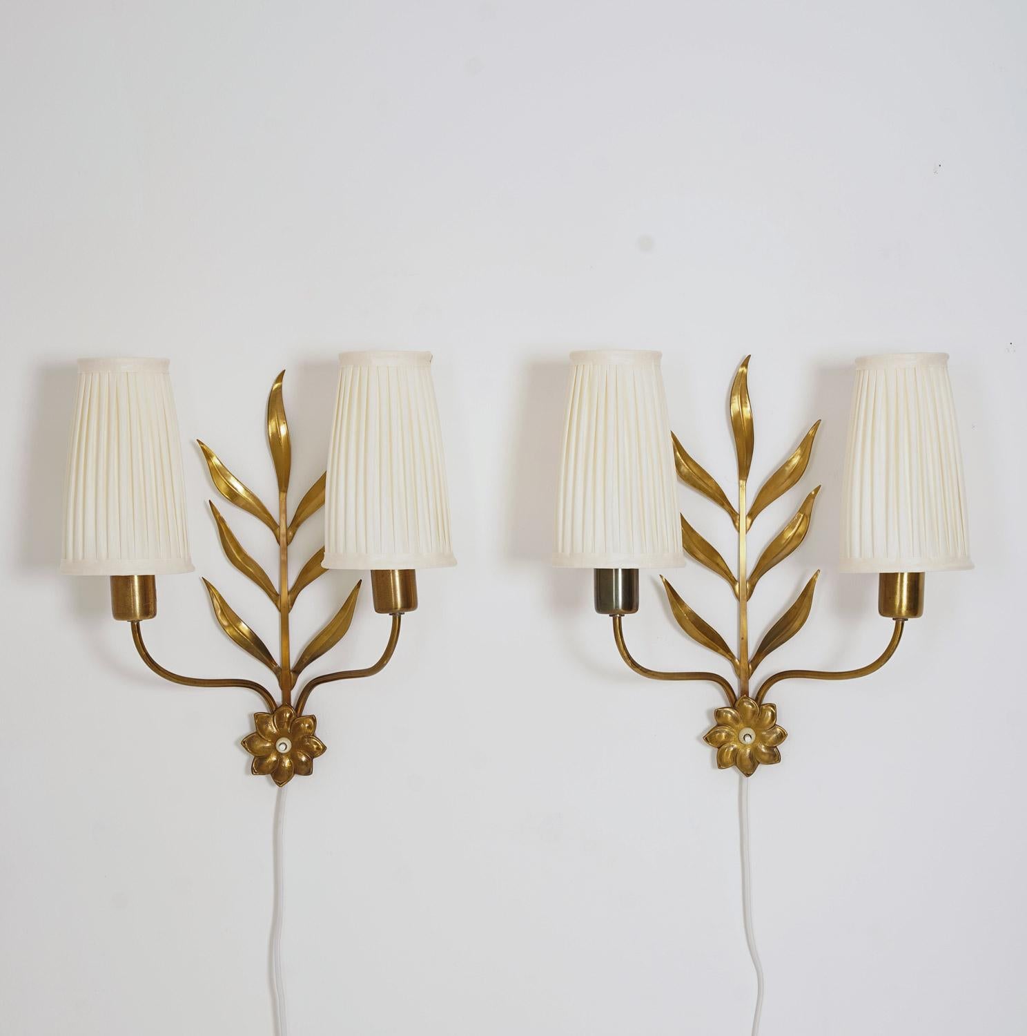Charming pair of wall lamps, most likely produced in Sweden ca 1950.
The lamp is made of brass with floral ornaments and comes with pleated fabric shades.
Condition: Very good vintage condition with new hand-pleated shades.