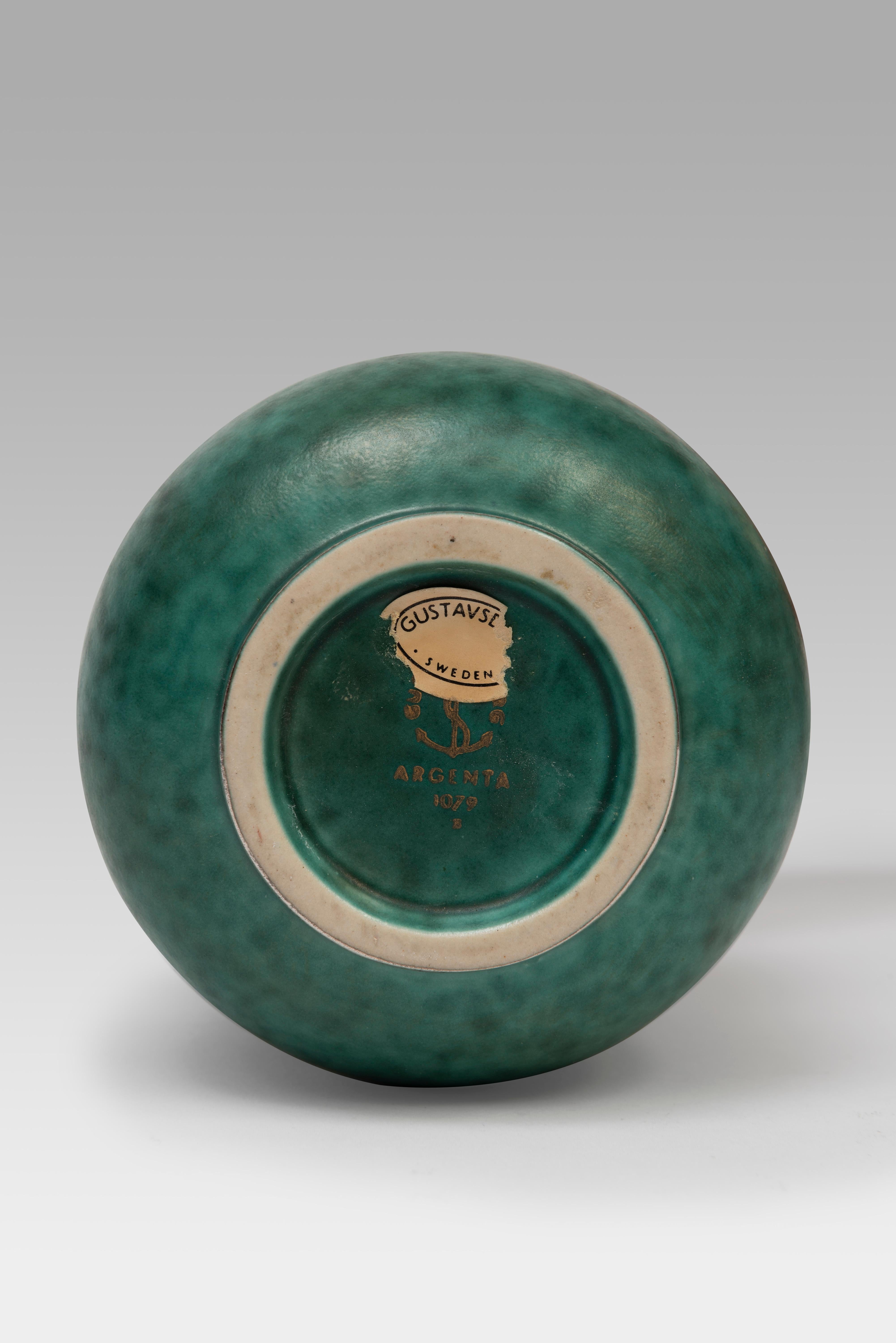 The Argenta  collection, now emblematic with its green glaze and silver decorations, is one of Wilhelm Käge's most recognizable motifs. Designed in the late 1920s, it was first presented at the Stockholm exhibition in 1930 and was then produced by