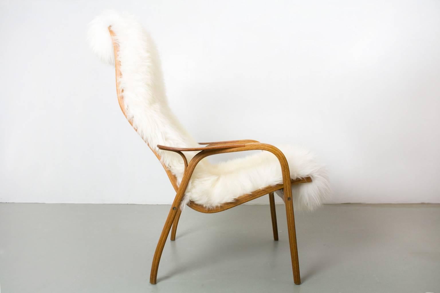 Scandinavian Modern at it's best. New upholstered with a very high quality long haired sheep skin. This lounge chair model “Lamino” was designed in 1951 by Yngve Ekström and manufactured by his company, Swedese, based outside of Nässjö. This lounge