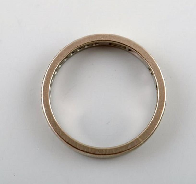 Swedish modernist alliance ring in 18 carat white gold with diamonds. Dated 1976.
In very good condition.
Stamped.
Measures: 17 mm. US size: 6.5.
In most cases we can change the size for a fee (50 USD) per ring.