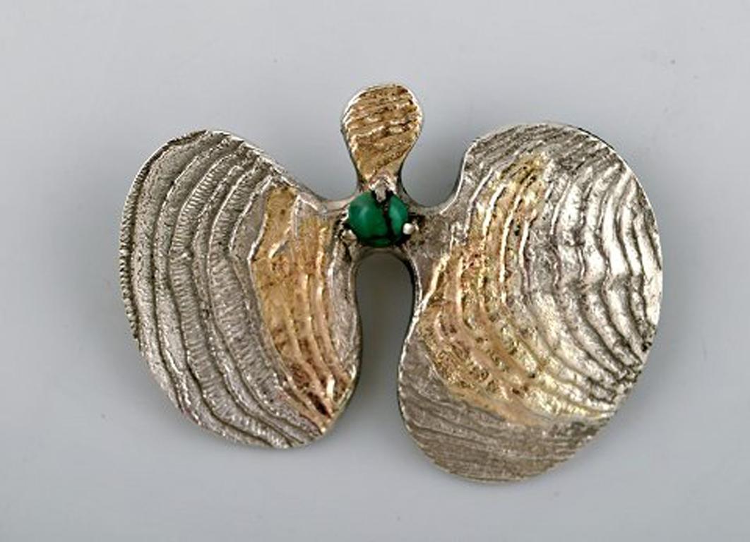 Swedish modernist brooch in silver with green agate, partially gilded. 1968.
In very good condition.
Measures: 6 x 4.5 cm.
Stamped.
