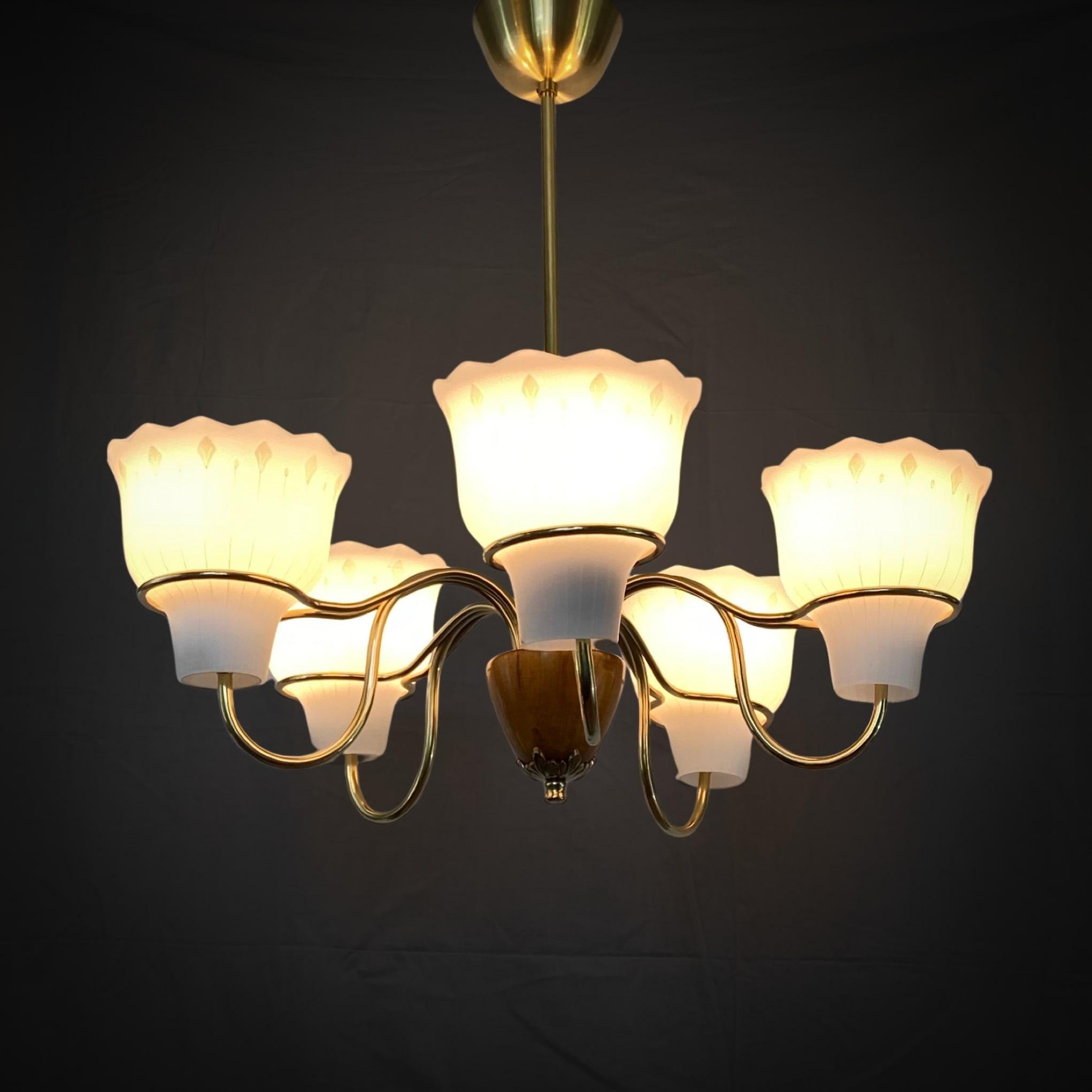 Swedish 1940s chandelier in the manner of Hans Bergström and ASEA. Brass frame with five flower-shaped glass shades held in place by beautiful brass rings. This type of construction was successfully used by Gunnar Asplund for several of his lamps.
