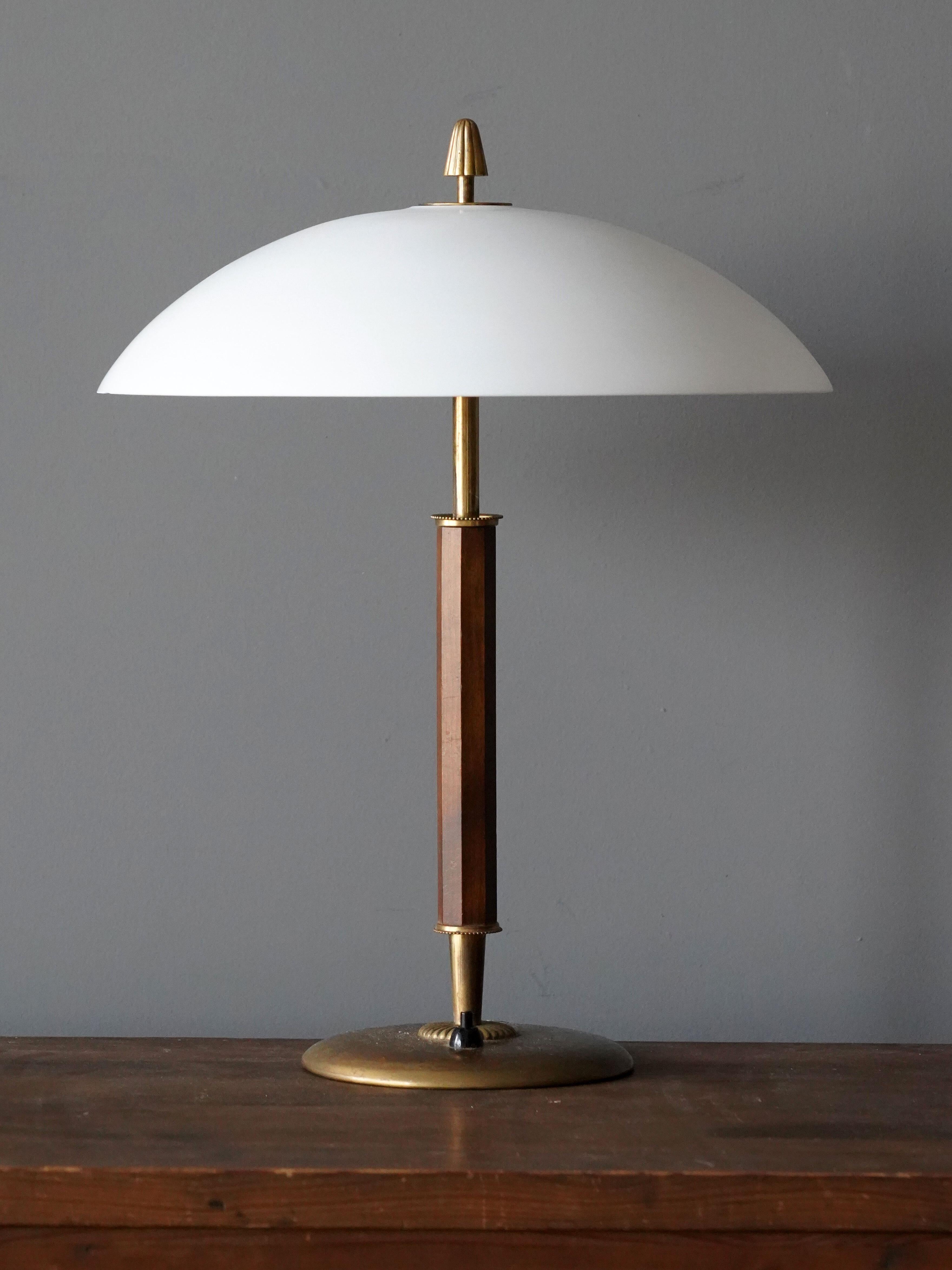 An early modernist table lamp. In brass and stained oak with inlays. Produced in Sweden, 1940s.

Other designers of the period include Paavo Tynell, Lisa Johansson-Pape, Carl-Axel Acking, and Gunnar Asplund.