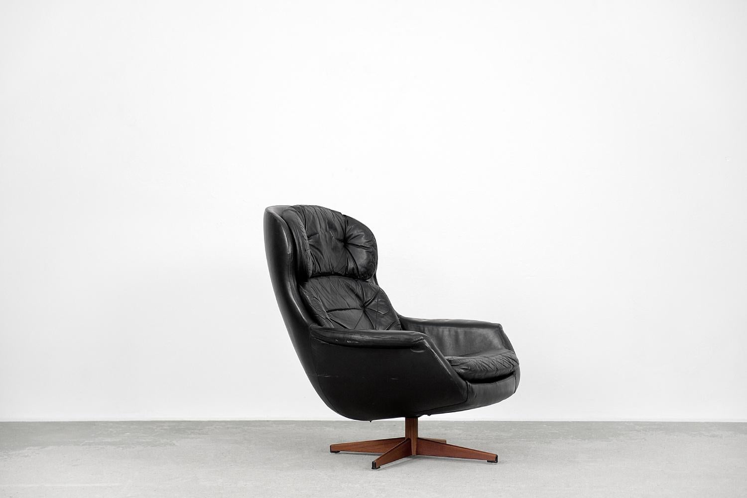 This modernist swivel armchair was manufactured by Selig Imperial in Sweden during the 1970s. The armchair is made of black natural leather. The base is a chrome star-shaped base covered with brown veneer. The back cushions are loosely attached with