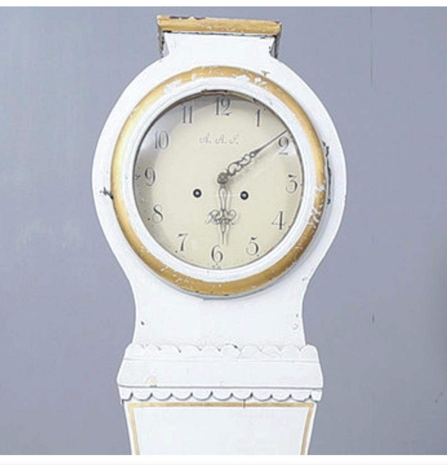 ecorative early 1800s antique Swedish mora clock with carved detail in a white and gold later paint finish with mora written on the clock face. 

Measures: 203cm.

This original 1800s mora clock has a nice face with a clean patina and some enamel