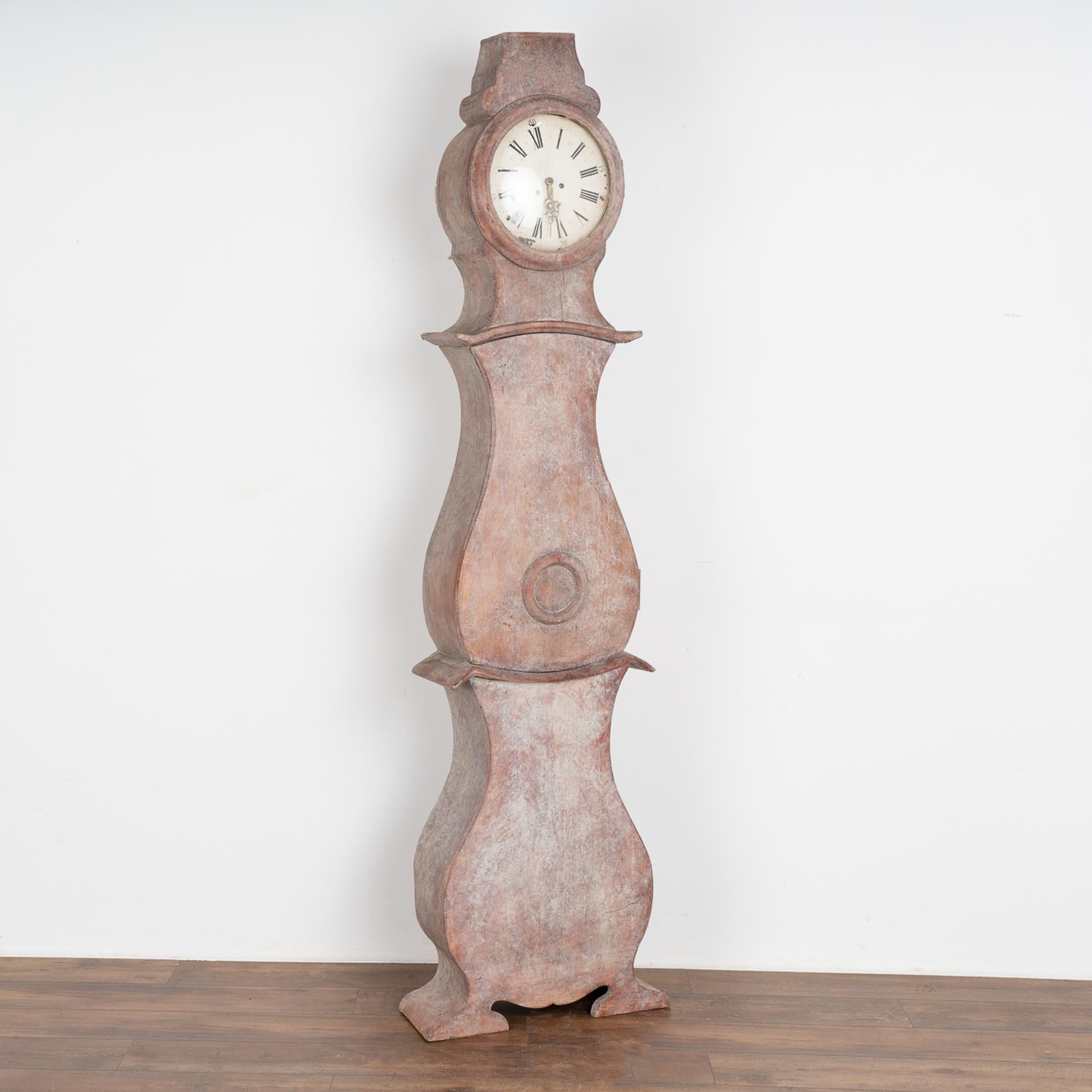 Graceful curves and unique lines create the attractive silhouette of this Swedish mora grandfather clock.
Newer professionally applied painted finish with layers of plum, white and gray are lightly distressed to fit the age of clock.
Original clock