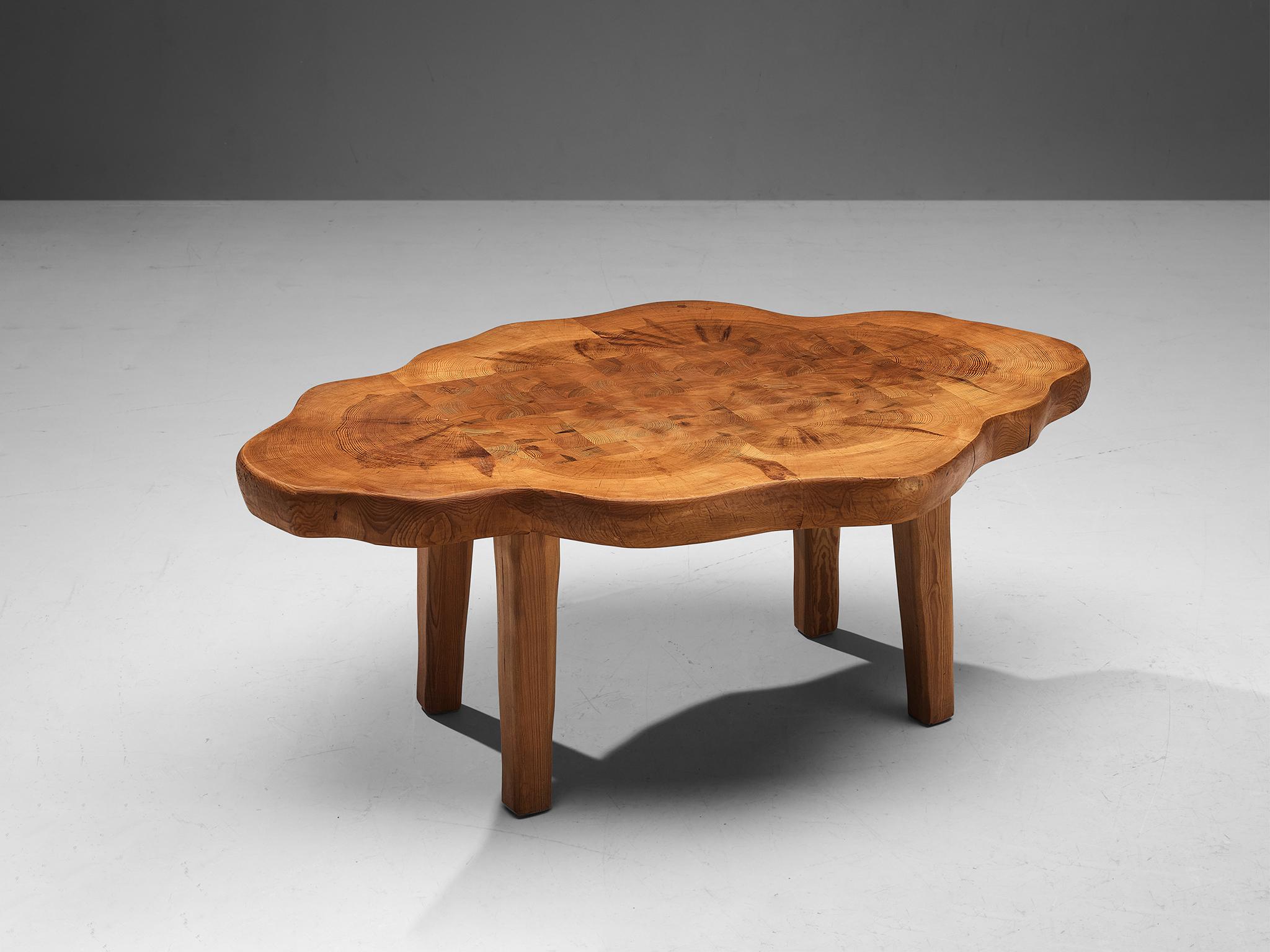 Coffee table, pine, Sweden, 1960s 

The top of this wonderful coffee table is hand carved out of multiple thick pine tree slabs, resulting in a vivid composition of curvaceous lines. Therefore, the surface features a striking checkered pattern