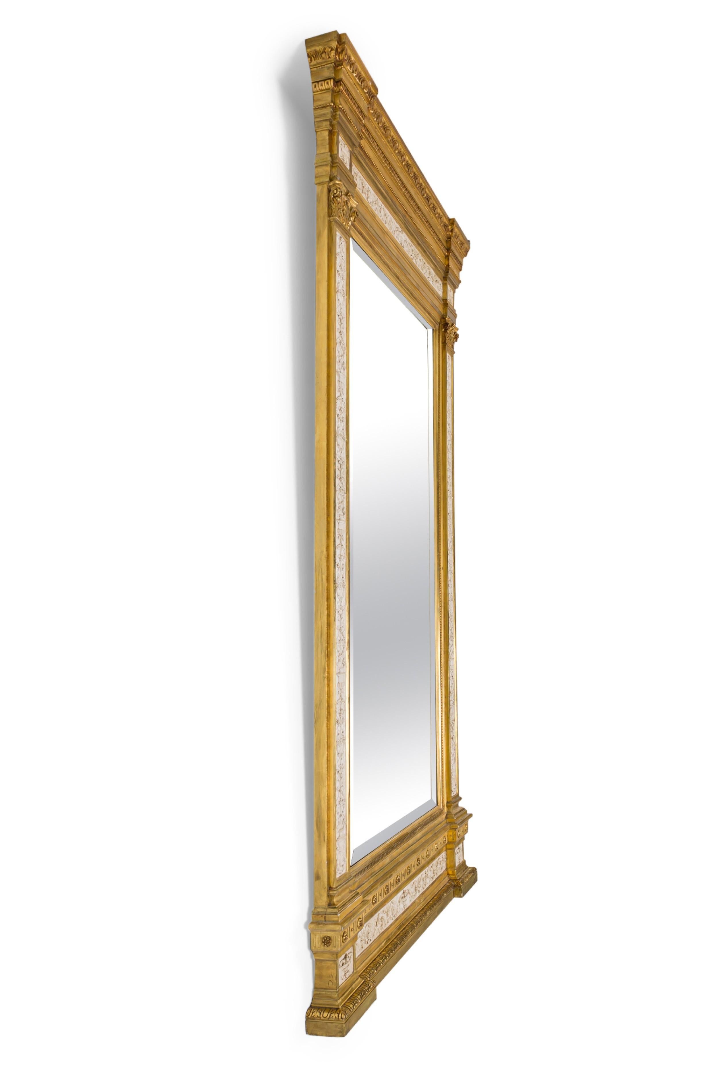 Miroir mural monumental de style néo-classique suédois (19e siècle) à motif de colonnes sculptées, parcellaire doré et peint dans une finition crème.

Pertes de finition compatibles avec l'âge