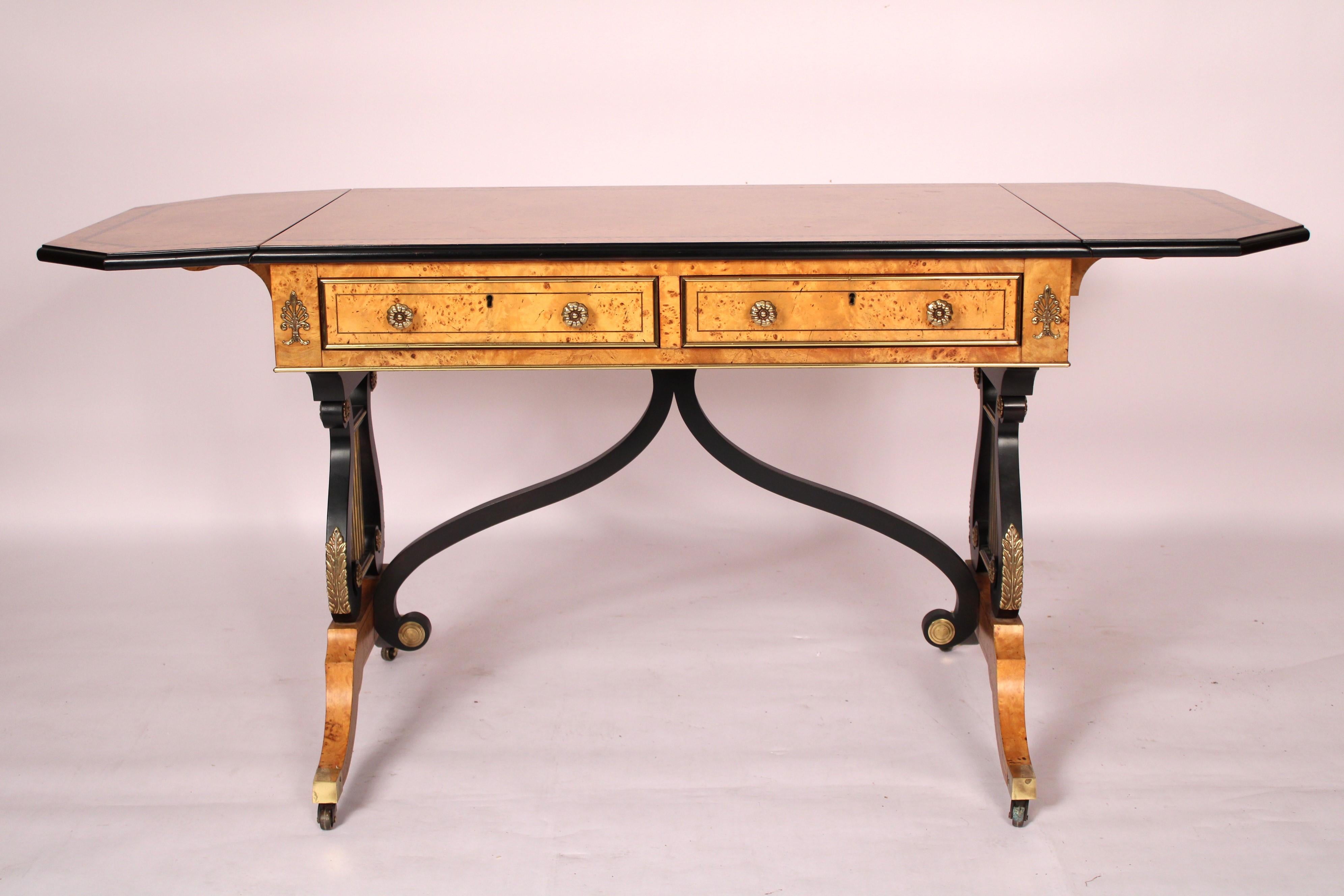Neo classical style burl wood, lacquer and brass Writing / Sofa table, made by Baker Furniture Co., late 20th century. With a burl wood rectangular top with drop leaves on both sides with canted corners, the top with inlay and black lacquer cushion