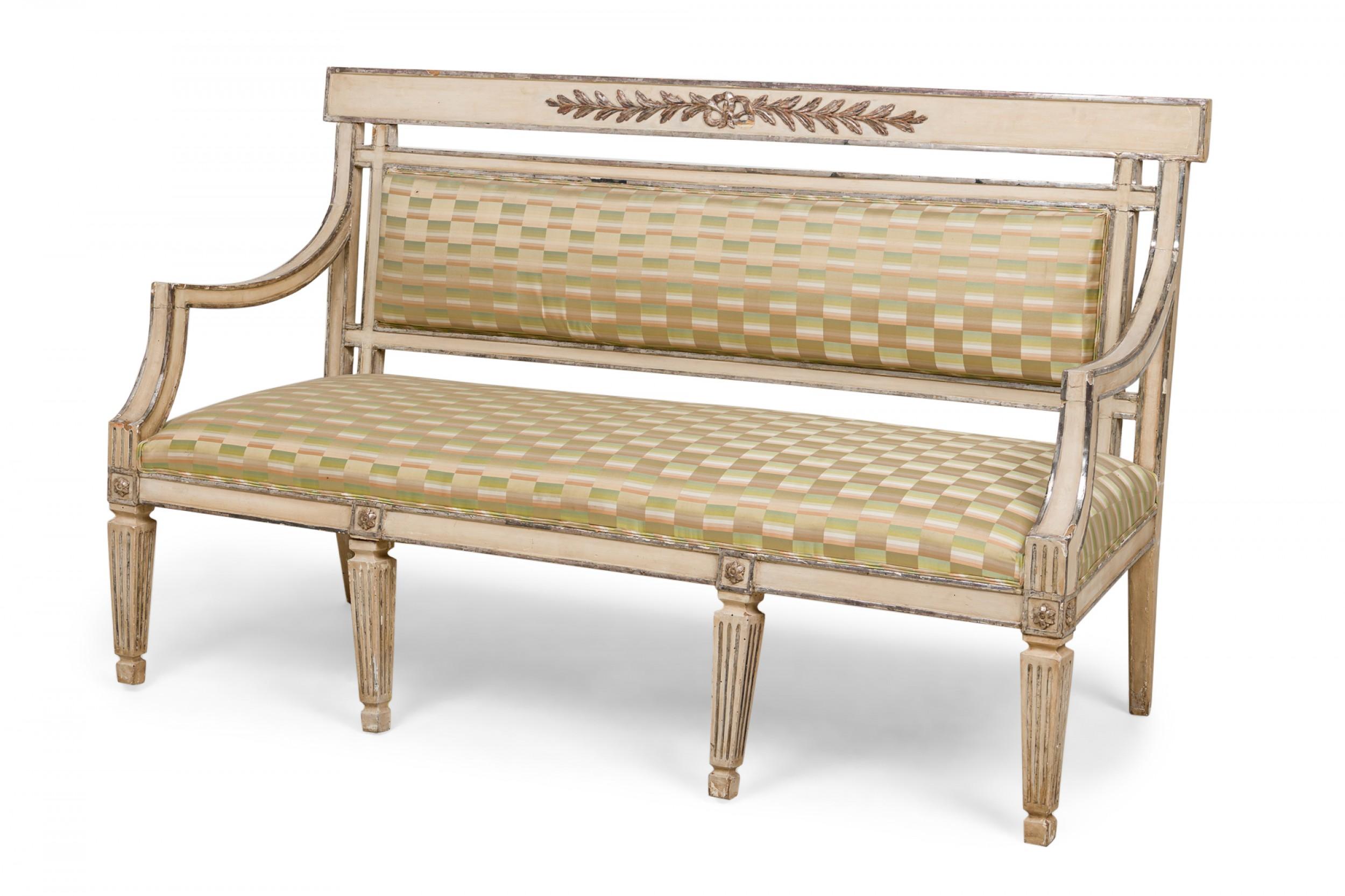 Swedish Neo-Classical settee with a carved wooden frame, painted white and parcel silver gilt, with decorative silver giltwood foliate carvings and rosettes, the seat and back upholstered in a checkered sage green and beige striped and checkered