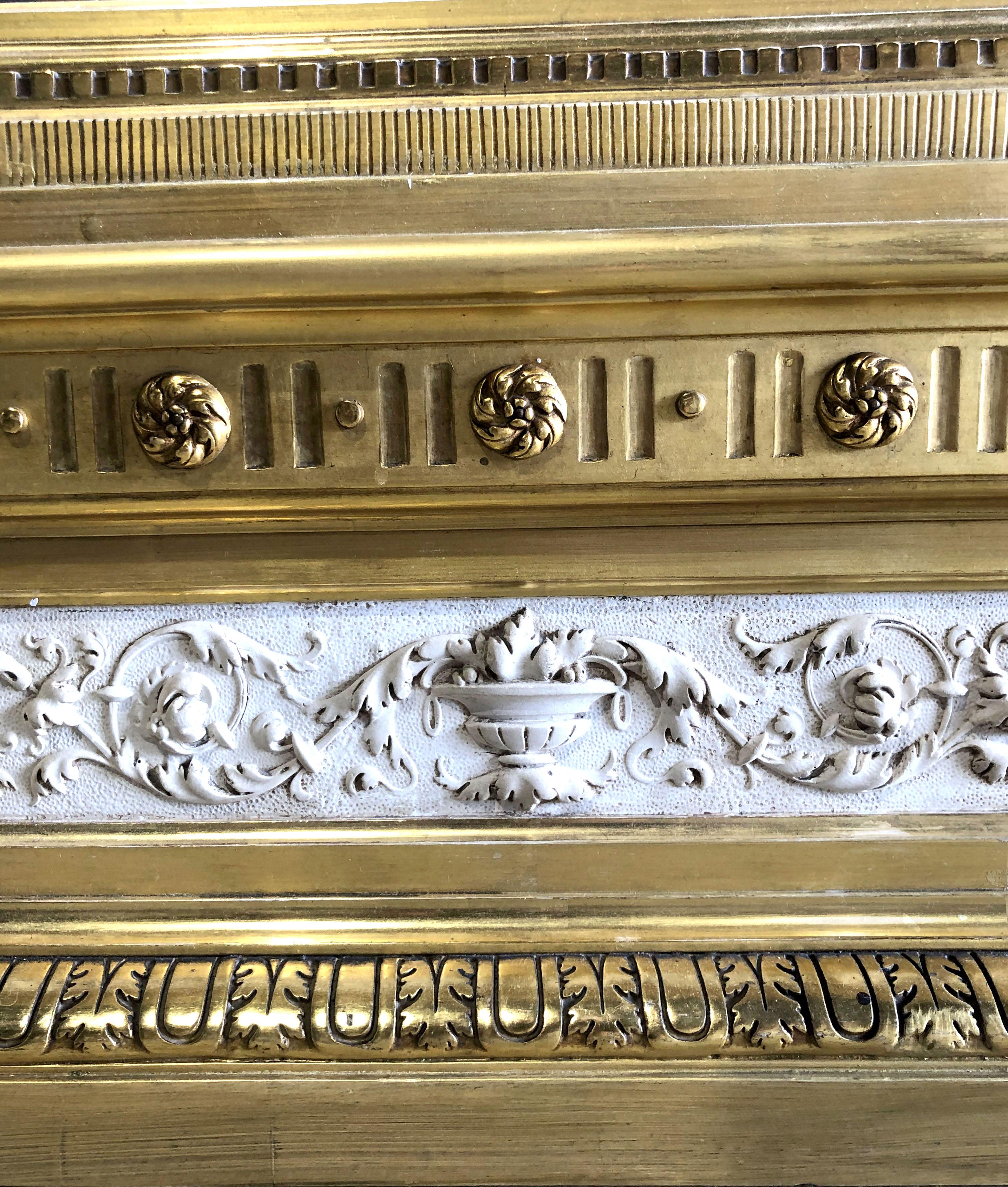 The monumental size mirror (glass plate replaced) with carved and gilded moldings above a plaster frieze and flanked by columns- original water gilding- minor restorations- excellent condition, early 19th century.