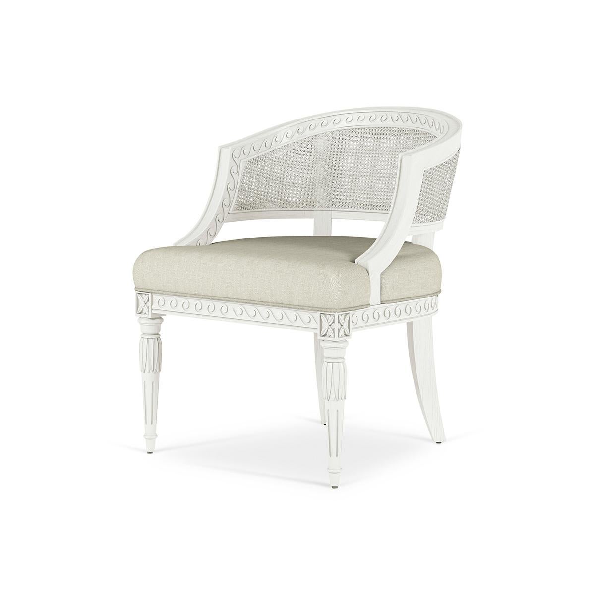 Swedish Neoclassic style painted Armchair, with a caned barrel back accented with carved Vitruvian scrolls, a tight seat upholstered in performance Belgian linen sits on exquisite fluted spindle legs for an elegant aesthetic with hints of European