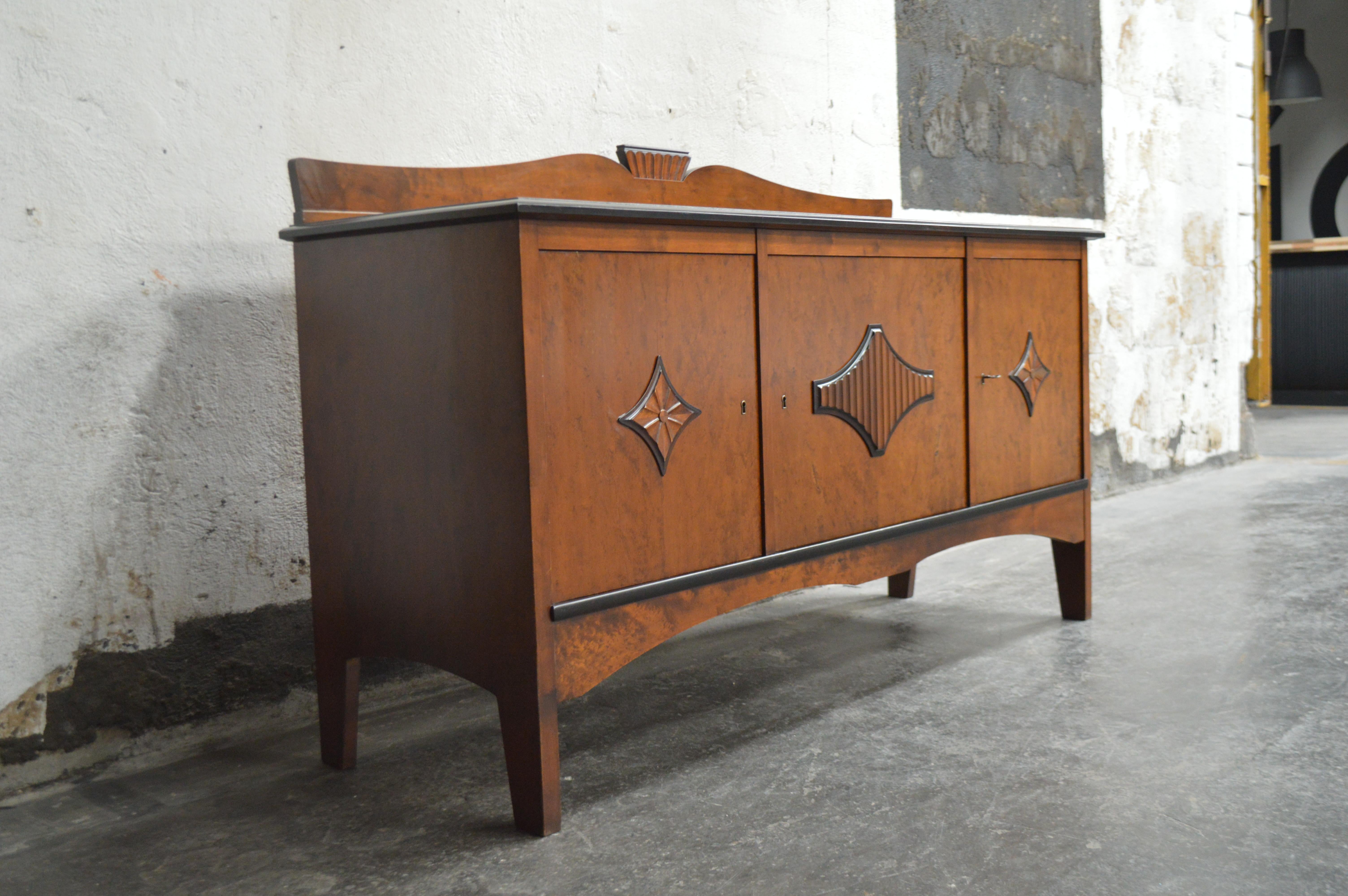 Gorgeous Swedish Neoclassical or Biedermeier style buffet, sideboard or credenza with dark golden birch with ebonized trim. Two doors on the sides and one center door open to reveal shelving and four drawers in the center. Beautifully detailed with