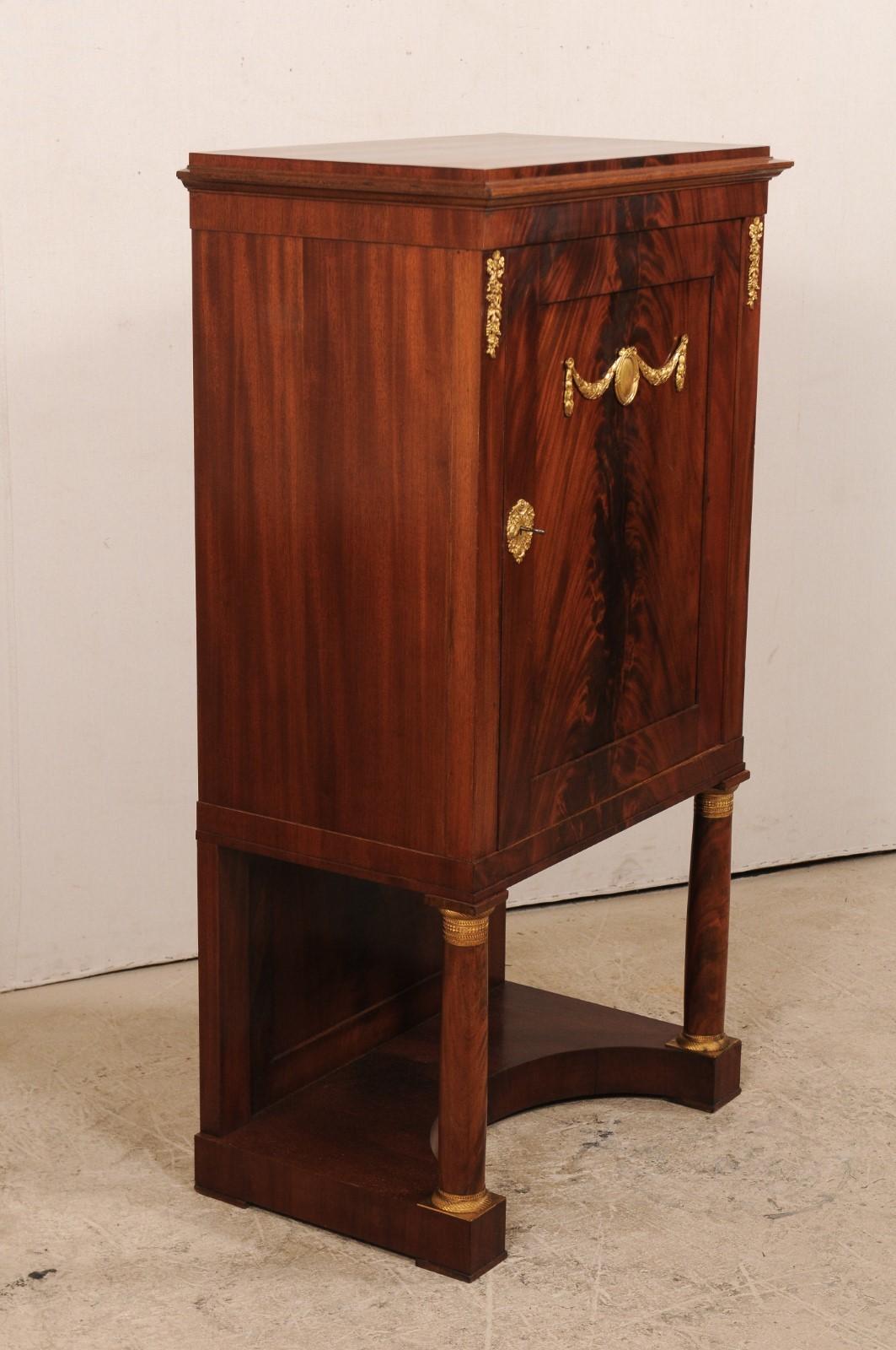 Armadio rialzato neoclassico svedese della metà del XIX secolo. Questo mobile antico proveniente dalla Svezia presenta una cassa superiore con un'anta singola che poggia su due gambe anteriori arrotondate e un retro venduto, con una base