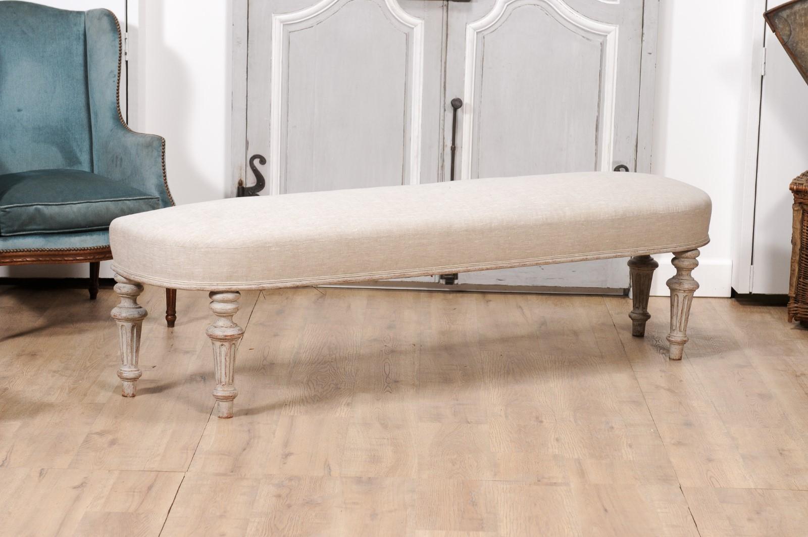 A Swedish Neoclassical style painted wood bench from circa 1860 with carved fluted legs and distressed finish. Embracing the exquisite subtlety of Swedish Neoclassical design, this painted wood bench from circa 1860 is an impeccable expression of