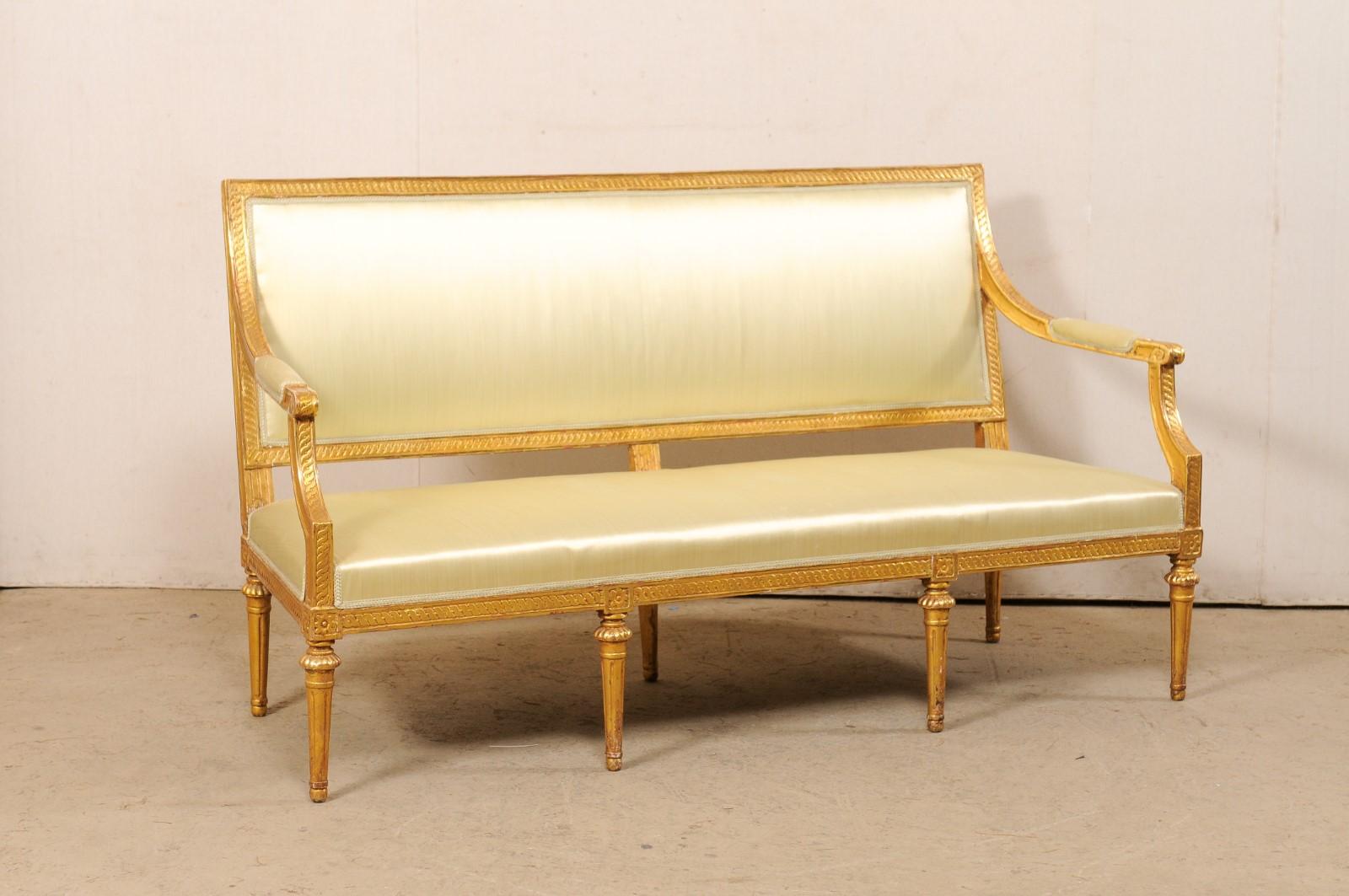 A Swedish Neoclassic style gilt-wood and upholstered sofa bench from the 19th century. This antique sofa from Sweden, approximately 5.75 feet in length, features a rectangular-shaped back with straight crest rail, carved in twisted rope trim motif,