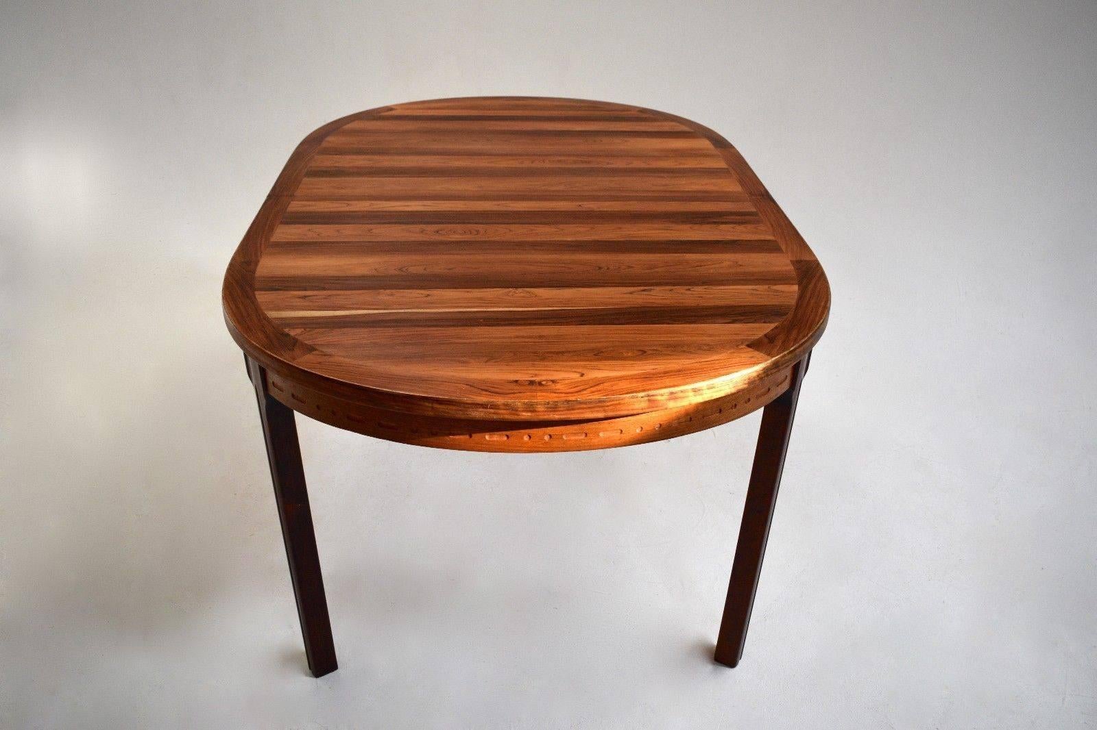 A beautiful Swedish rosewood dining table designed by Nils Jonsson for Troeds, this would make a stylish addition to any dining area. 

The table has a cross grain border and detailing around the skirt. A striking piece of classically designed