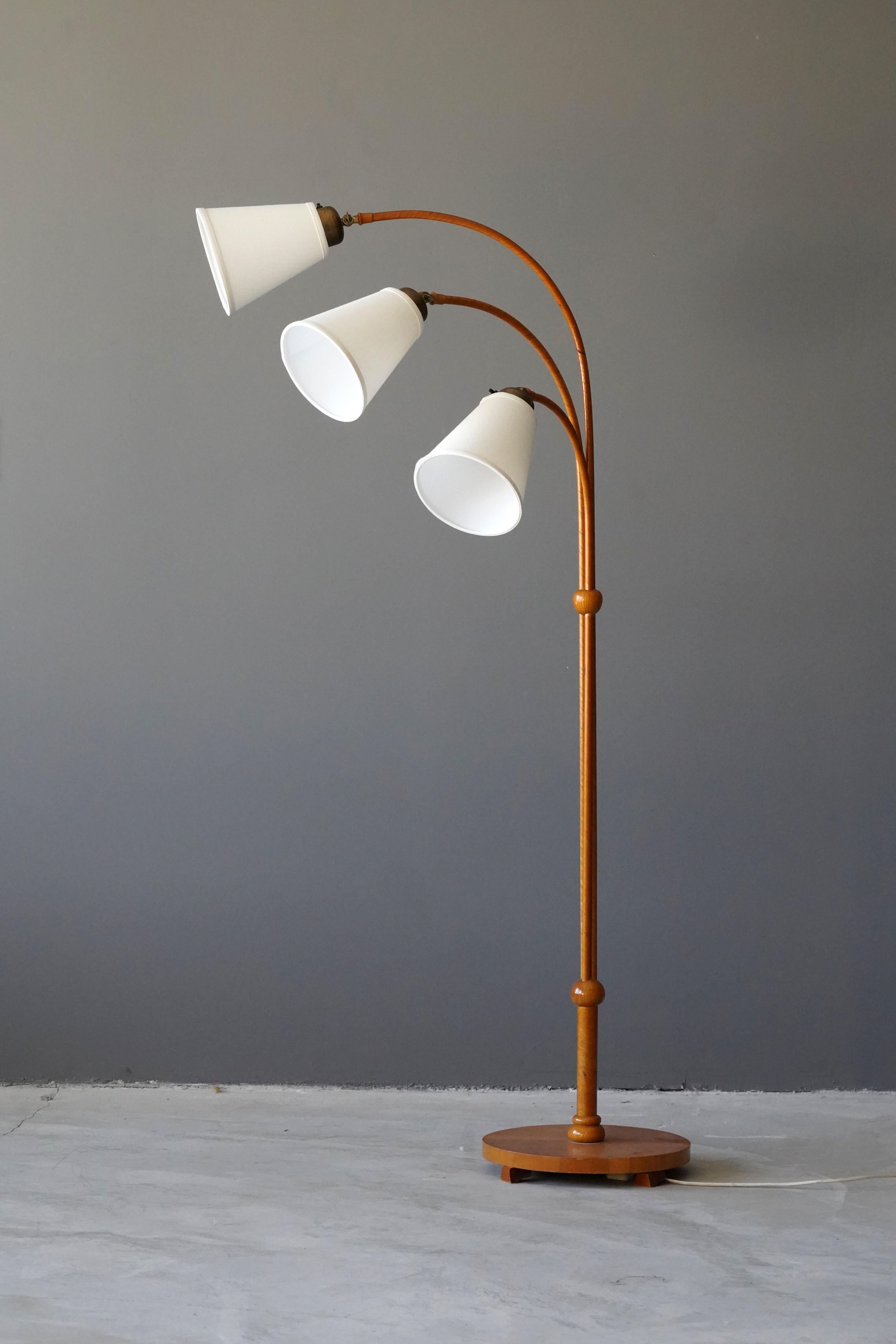 Un lampadaire organique à trois bras. Conçu par un designer moderniste suédois inconnu, années 1930. Peut-être fabriqué par Böhlmarks. Fabriqué en rotin, bois, lin et laiton. 

Parmi les autres designers travaillant dans le style organique, citons