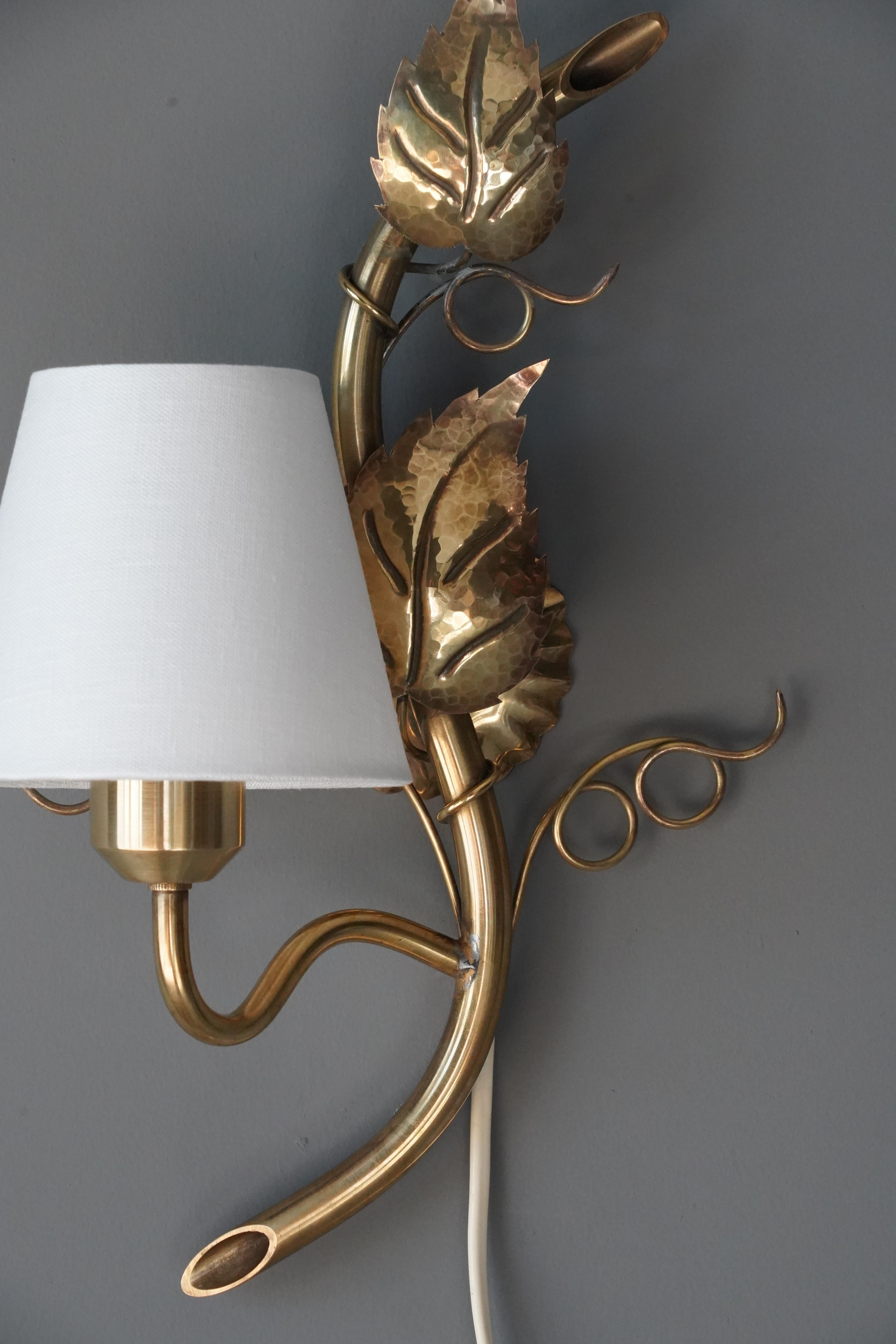 A wall light. Designed and produced in Sweden, c. 1940s-1950s. Features brass and brand new white fabric lampshade.

Dimensions include shade. Shade is included in purchase. Configured for plug in. Please review wiring upon installation.

