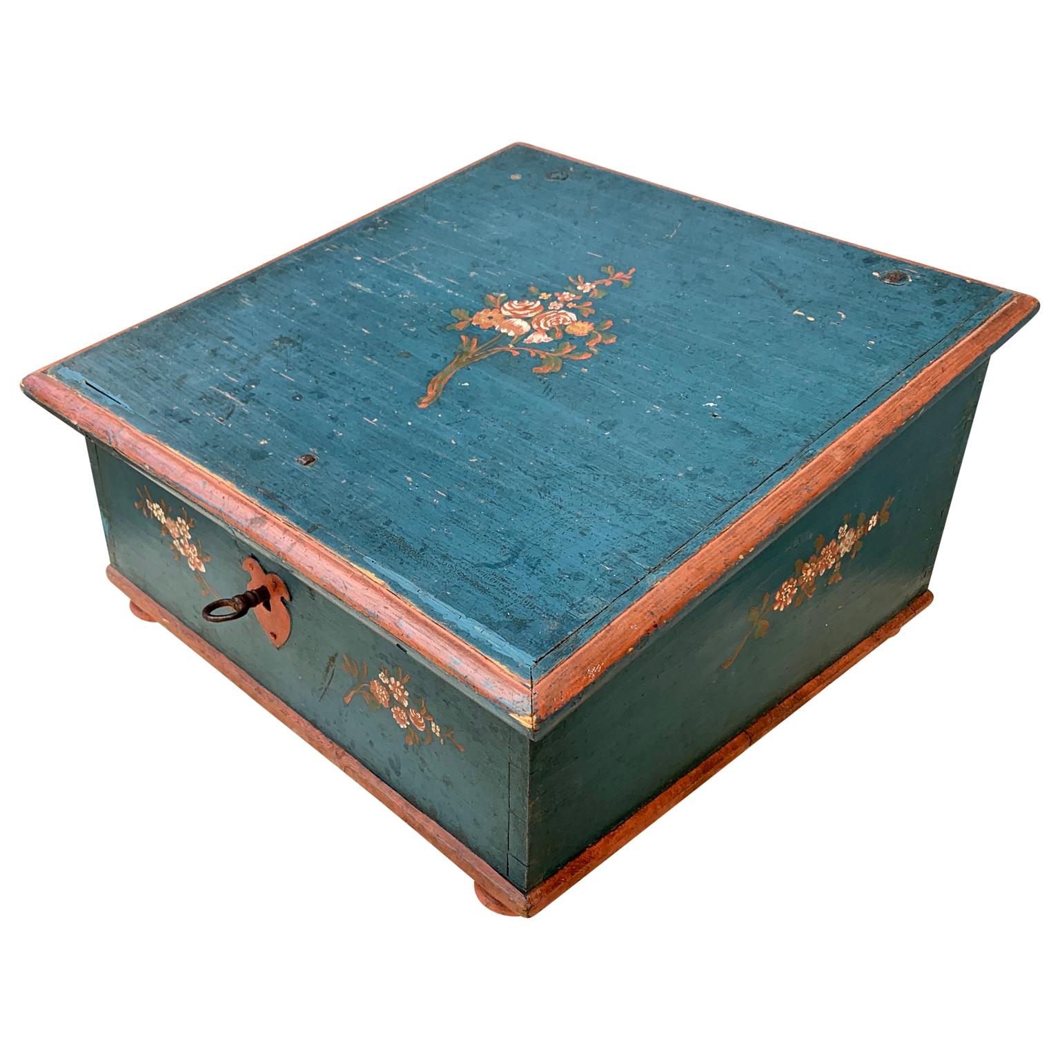 A Swedish blue and red painted pine-wood box from the Gustavian period or the early 19th Century. The hand painted flower decoration has still the remaining of the rococo period kind of painting floral pattern. This Scandinavian folk art box is
