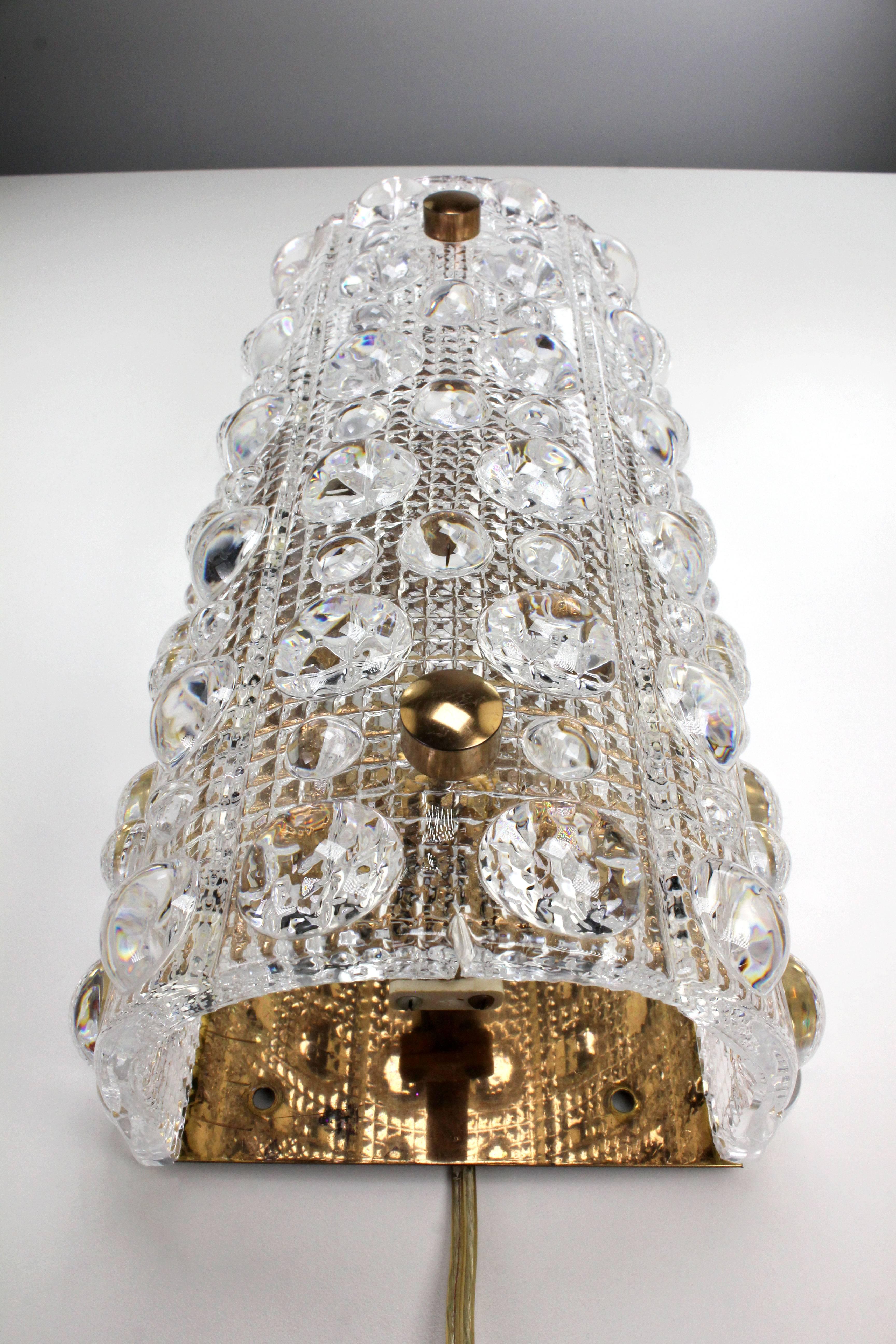 Stunning bubble textured crystal wall sconce by Swedish designer Carl Fagerlund for Orrefors Glasbruk. Manufactured in the small town of Orrefors in Sweden in the 1950s. Beautifully curved glass plate on brass mount with brass hardware. No chips or