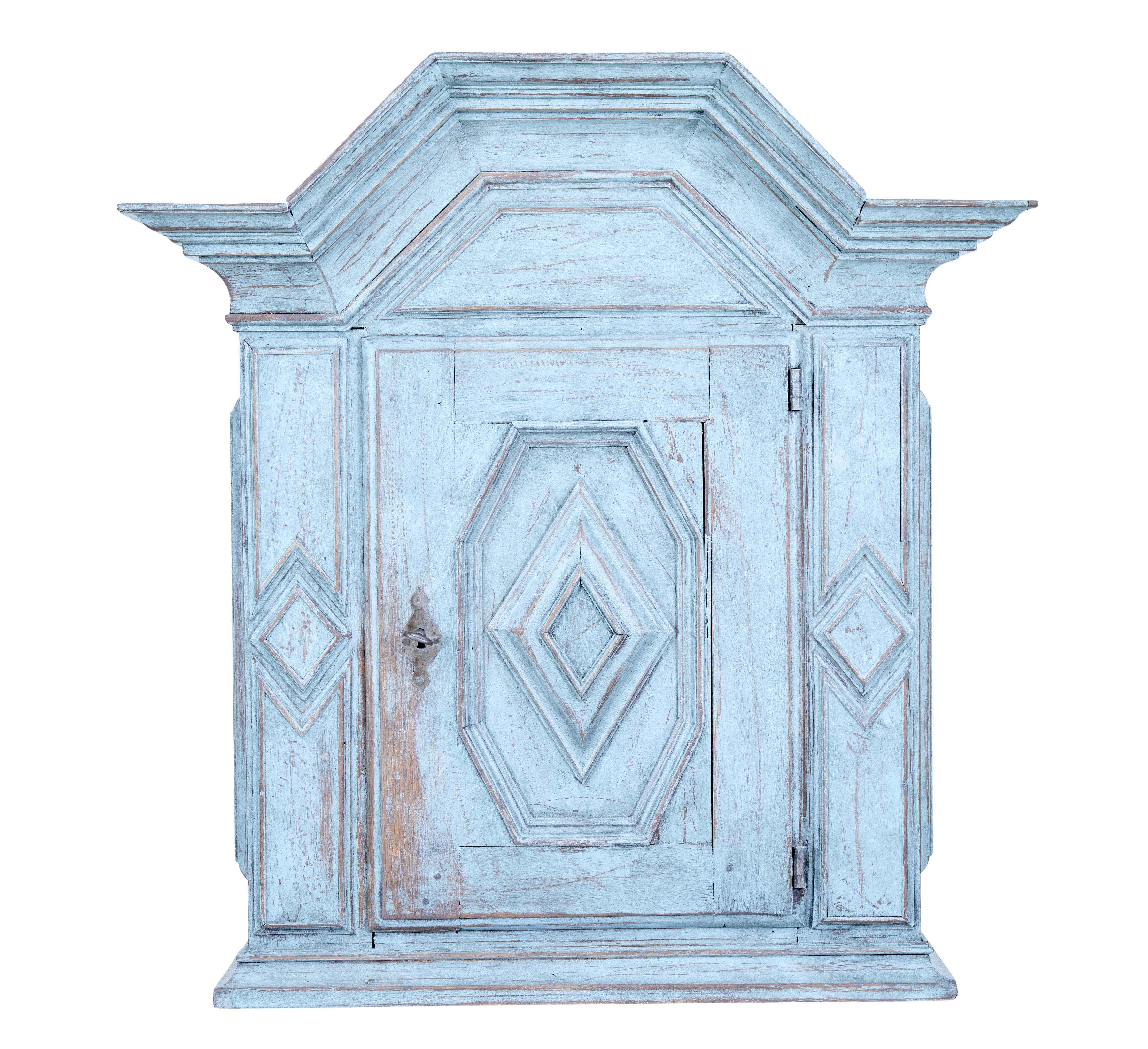 Swedish painted 19th century oak wall cabinet circa 1870.

Fine quality large oak wall cabinet with partial fitted interior. Large architectural cornice with baroque panelling to the single door. Interior opens to a single fixed shelf and 2 fitted
