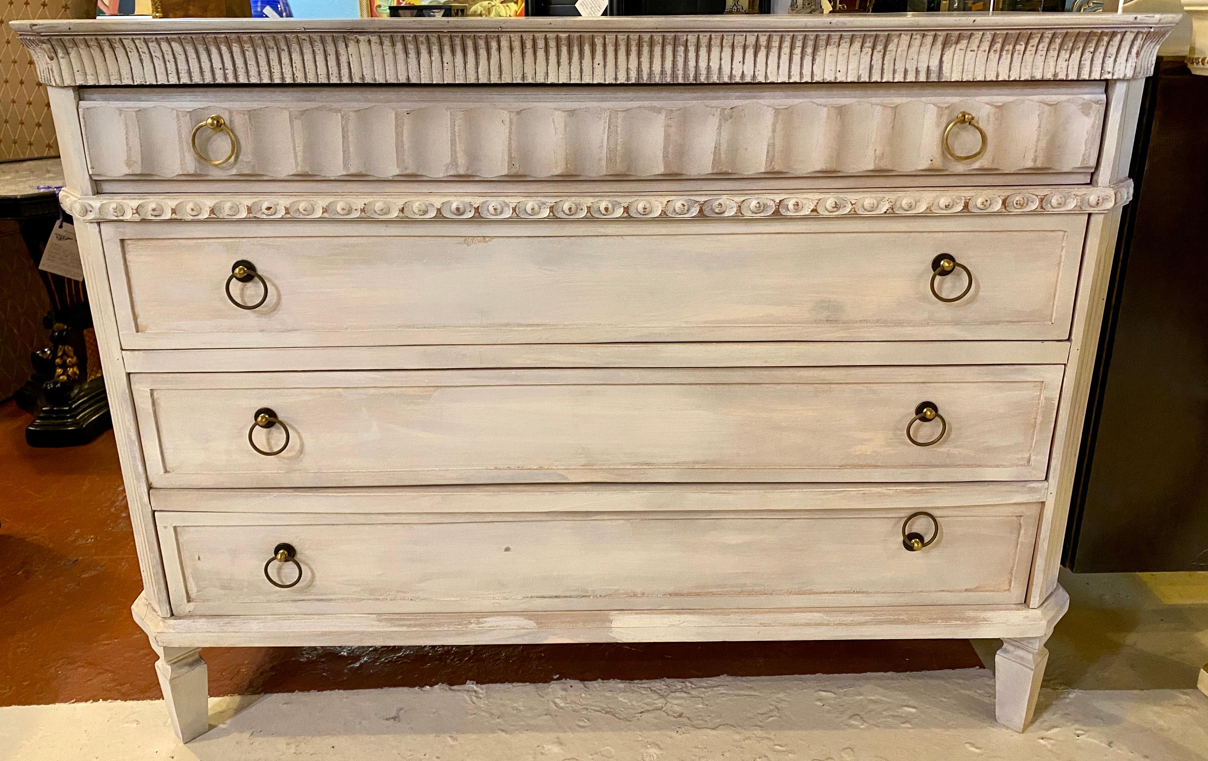 Pair of Swedish painted decorated commodes, chests or nightstands each having four drawers in a distressed finish. The smaller top drawer with carved reeded panel front with three larger drawers following.



 
