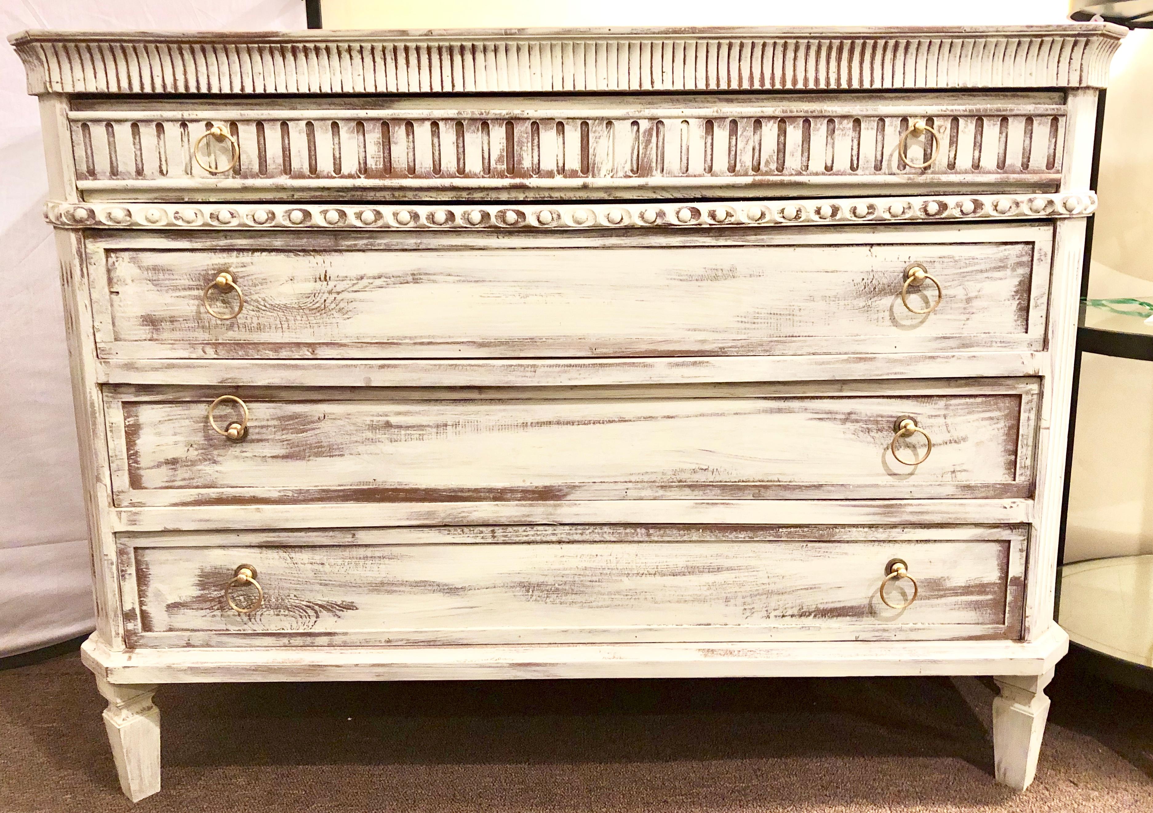 Pair of Swedish painted decorated commodes, chests or nightstands each having four drawers in a distressed finish. The smaller top drawer with carved reeded panel front with three larger drawers following.


Lia.