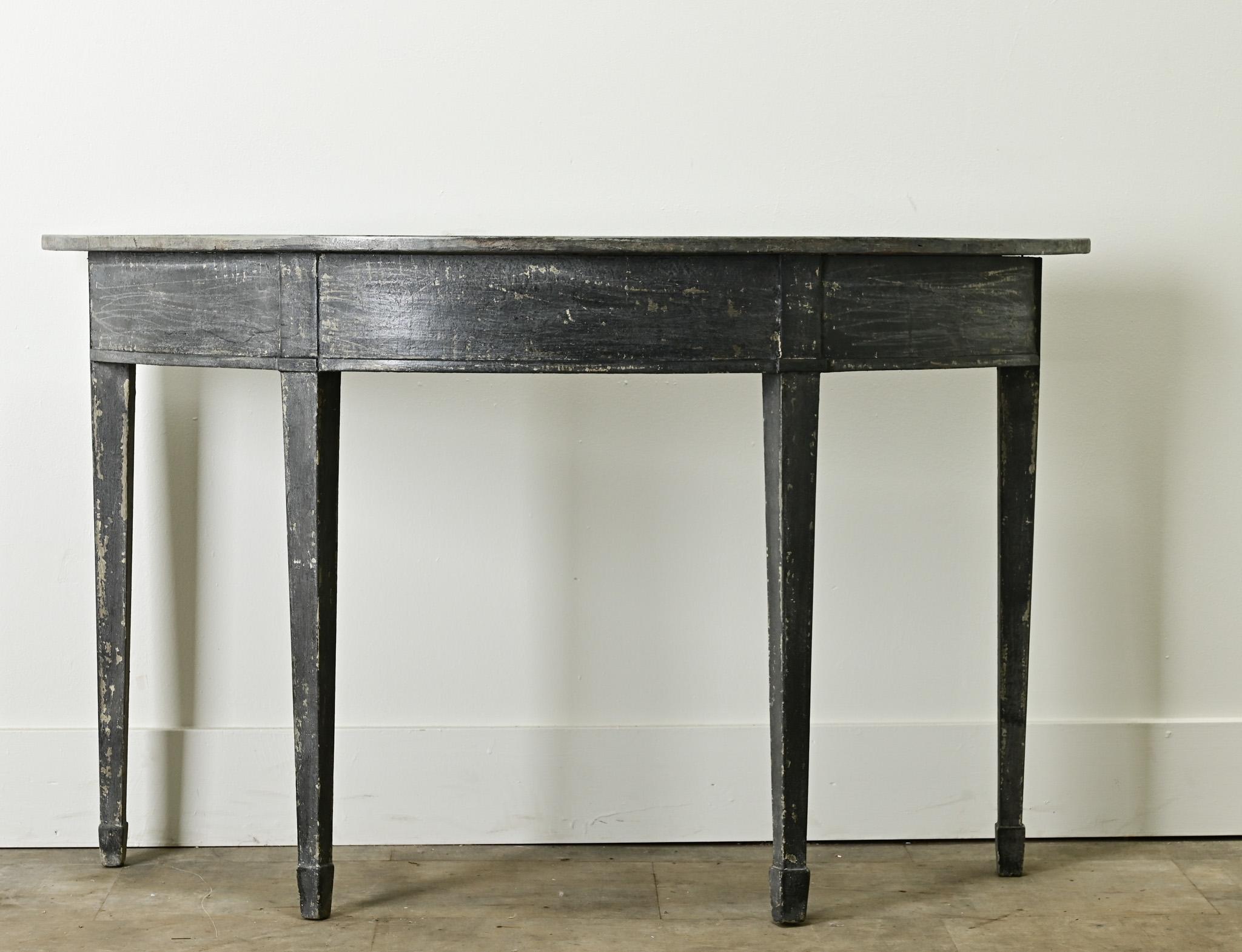 A Gustavian painted demilune console from 1900’s, Sweden. Simple in design, the top is shaped to fit its base with rounded edges and rests over four tapered legs. This console has a worn paint finish consistent with age and use, be sure to view the