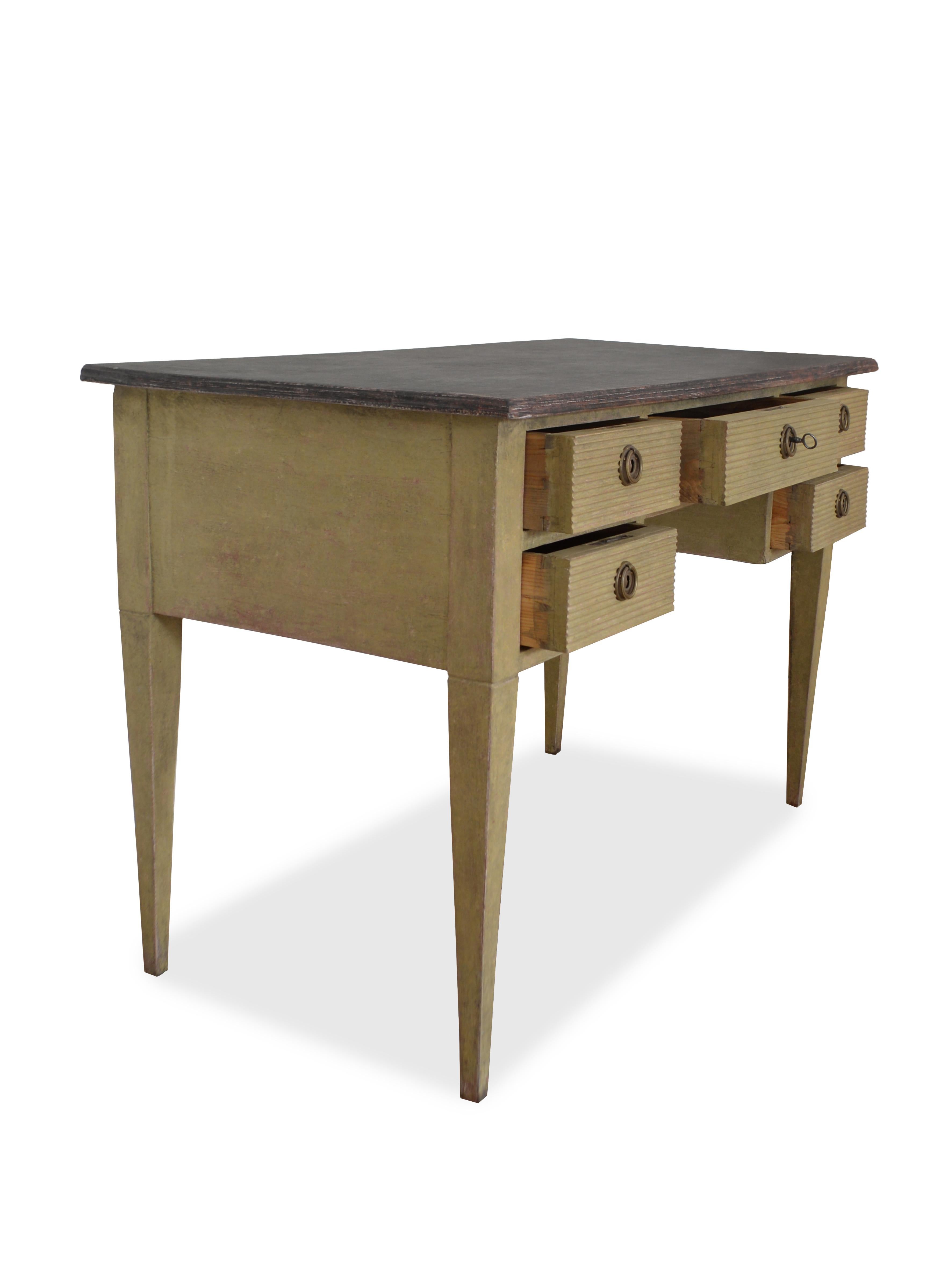 A Swedish five drawer desk from early 20th century in Gustavian style
The desk is painted in green and the top in black,
Both in an old traditional scandinavian way with fantastic patina.
Carved reeded drawers and straight tapered legs.

Healthy and
