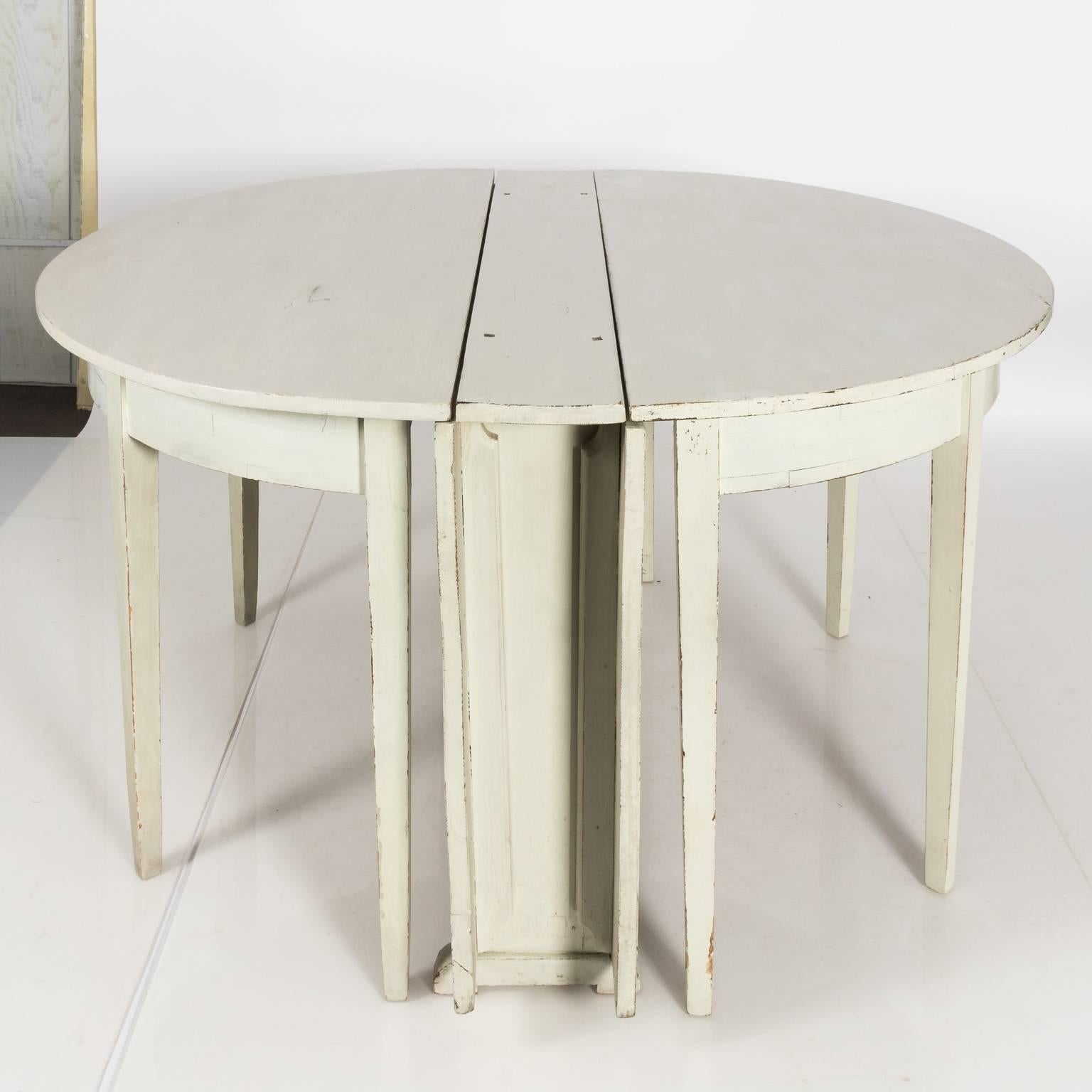 Gustavian white painted demilune dining table with two drop leaves and straight tapered legs, circa 19th century.