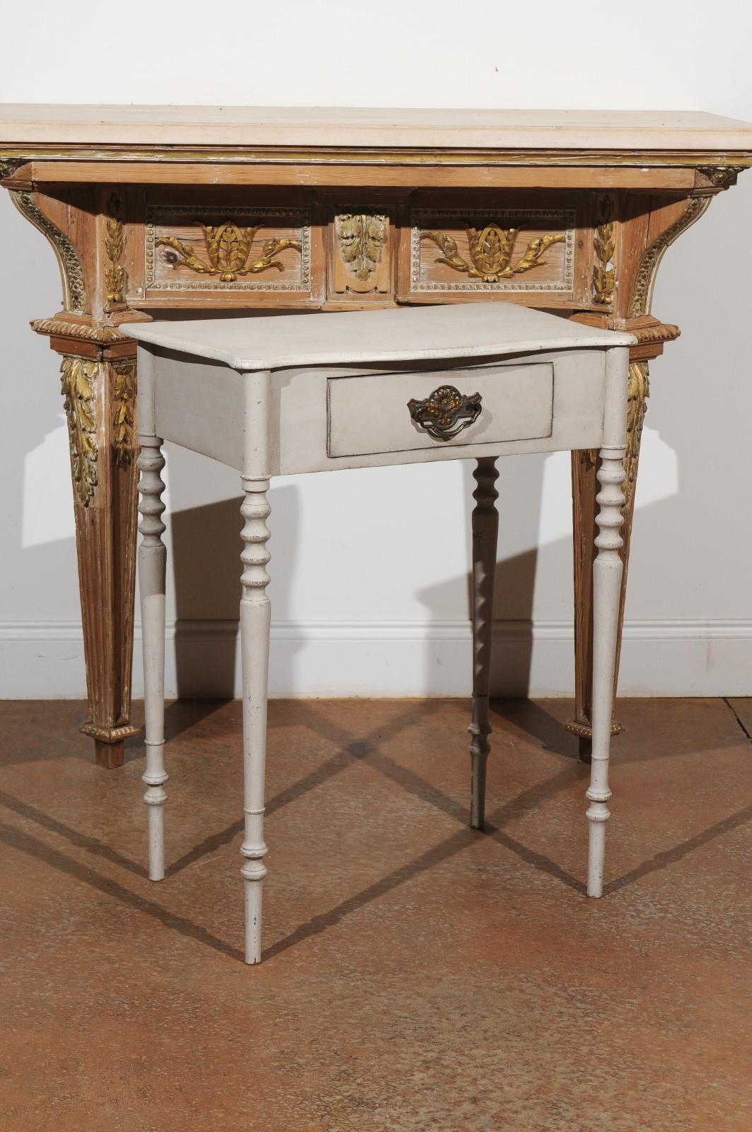 A Swedish small painted side table from the mid-19th century, with single drawer and turned legs. Born in Sweden during the mid-19th century, this lovely painted table features a rectangular top with serpentine front, sitting above a single