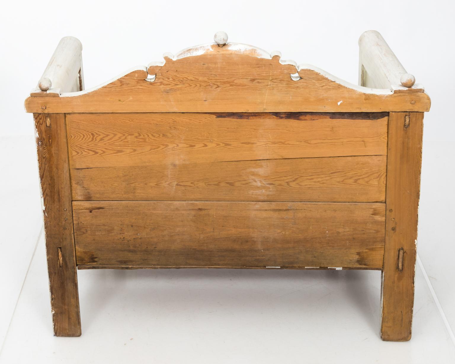 Swedish white painted bench with arms, a curved top rail, and bottom storage underneath seat, circa 1900.
 
