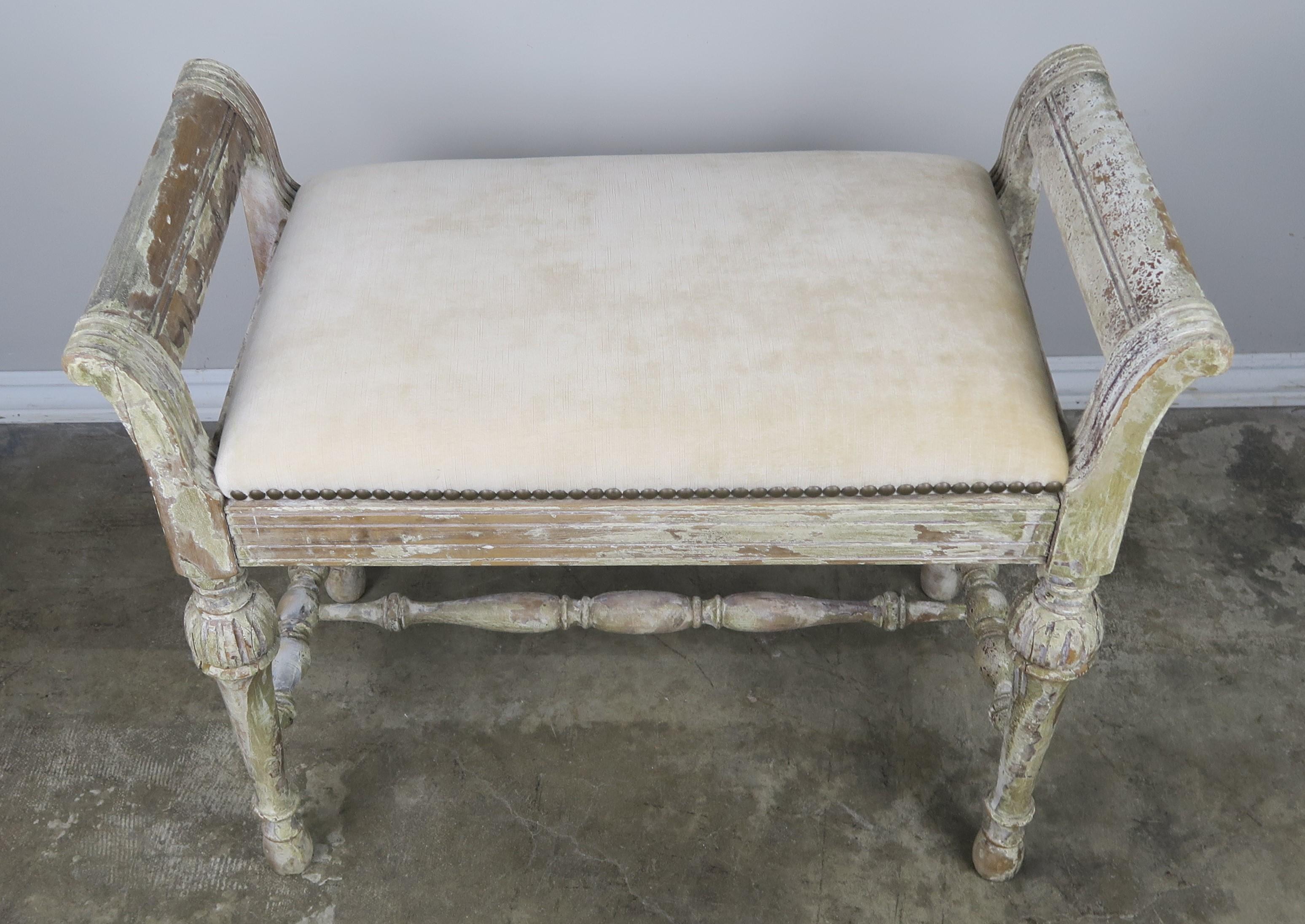 Swedish painted velvet upholstered vanity bench. The bench is newly upholstered in new cream colored velvet with antique brass colored nailhead trim detail.
Seat height 19