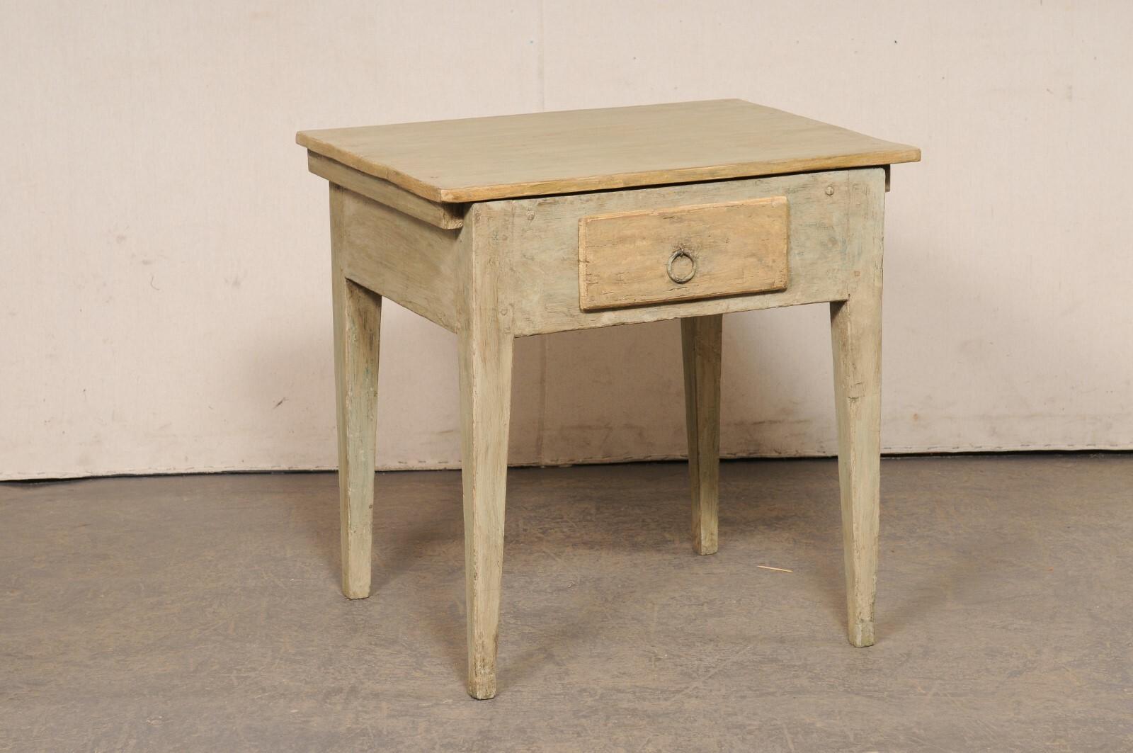 A Swedish painted wood side table, with single drawer, from the 19th century. This antique occasional table from Sweden features a rectangular top which rests above a deep-set apron that houses a small drawer at one side (with ring pull handle), and