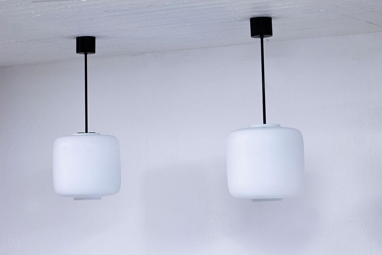 Scandinave moderne Paire de lampes à suspension suédoises en métal noir et verre opalin blanc mat, années 1950 en vente