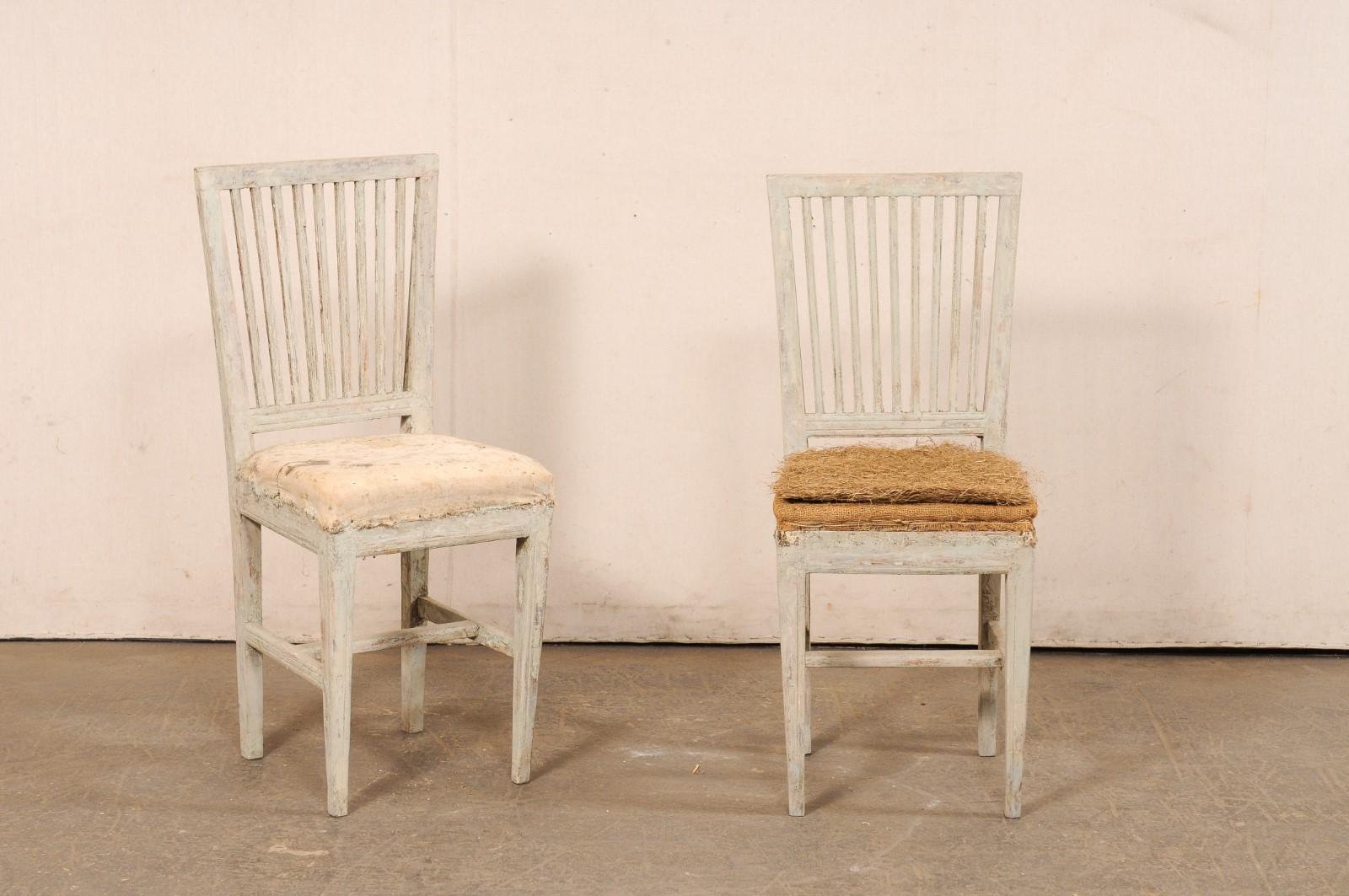 A Swedish Gustavian pair of slatted back side chairs from the early 19th century. These antique chairs from Sweden have a clean design with straight top rails and slatted backs. They are presented upon four squared, tapering legs which are supported