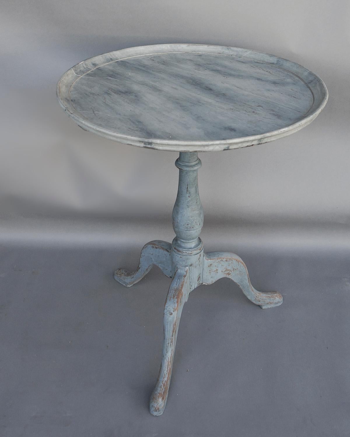 Round Swedish table, circa 1840, with tripod pedestal base in blue paint. The tray top has a beautifully marbleized surface in shades of blue, charcoal and Gustavian gray.